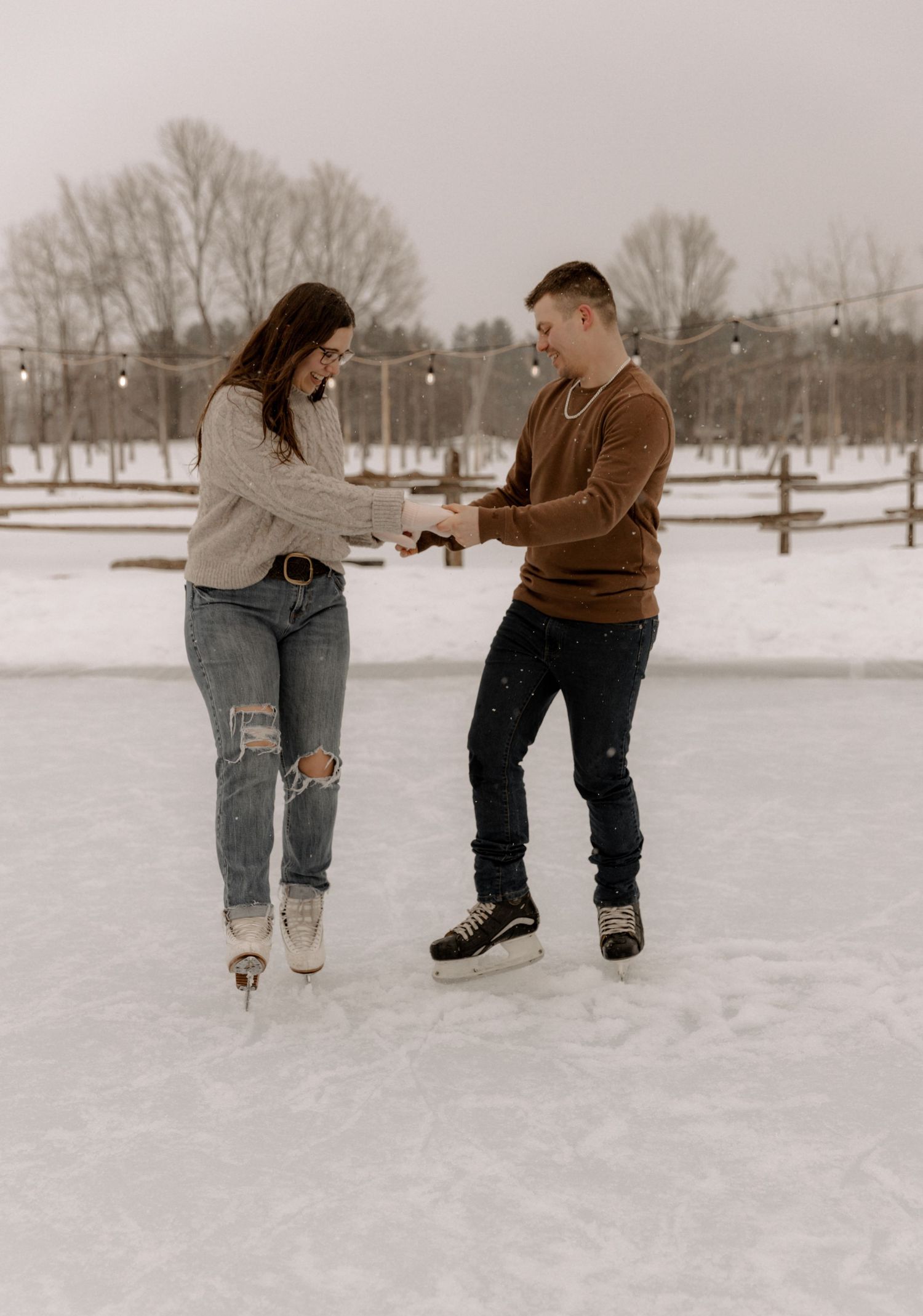 A couple ice skating together on a snowy winter day, sharing a sweet moment on the frozen rink.