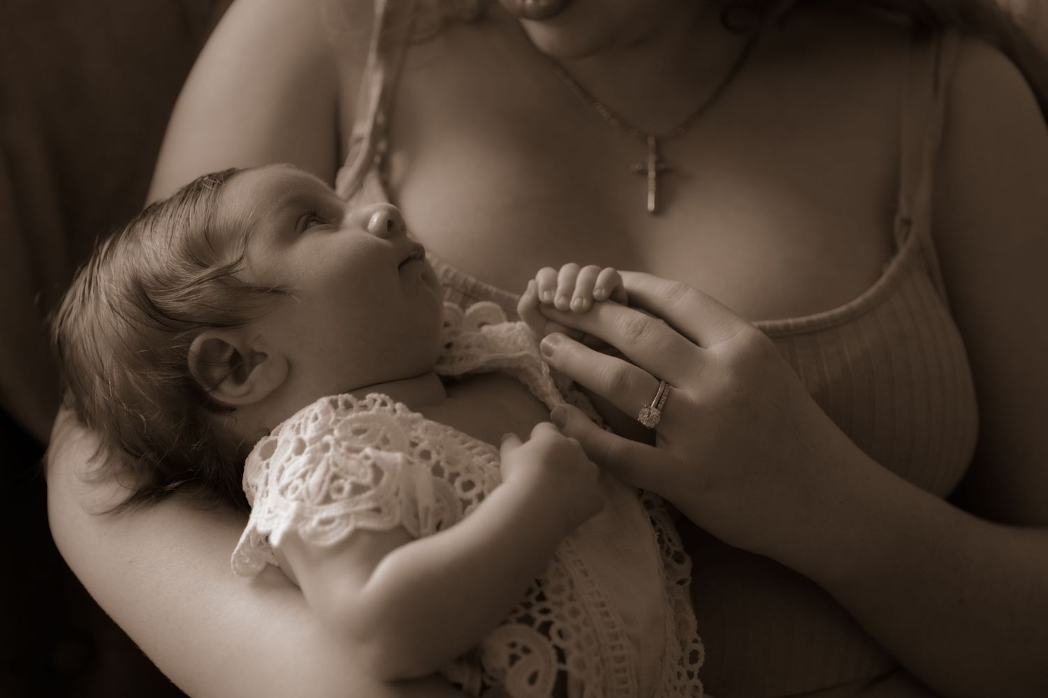 Sepia-toned intimate moment of feeding time between parent and infant.
