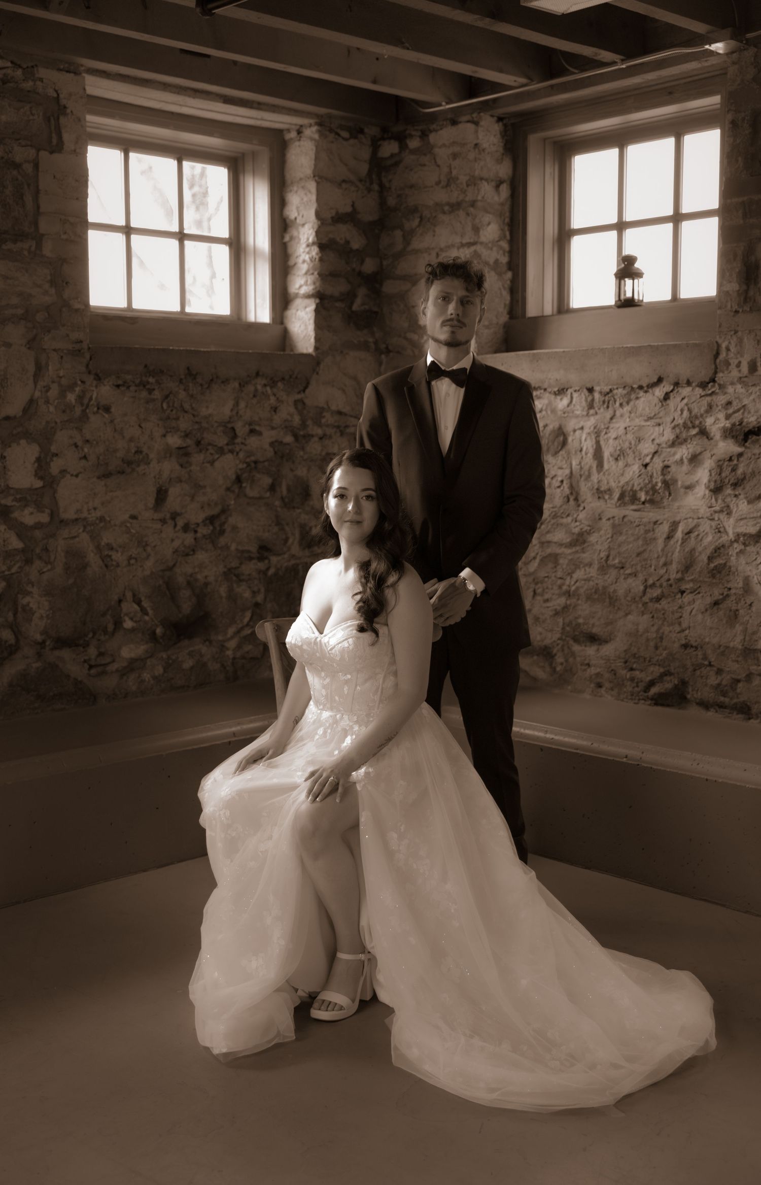 An elegant vintage-style portrait in a stone-walled room.