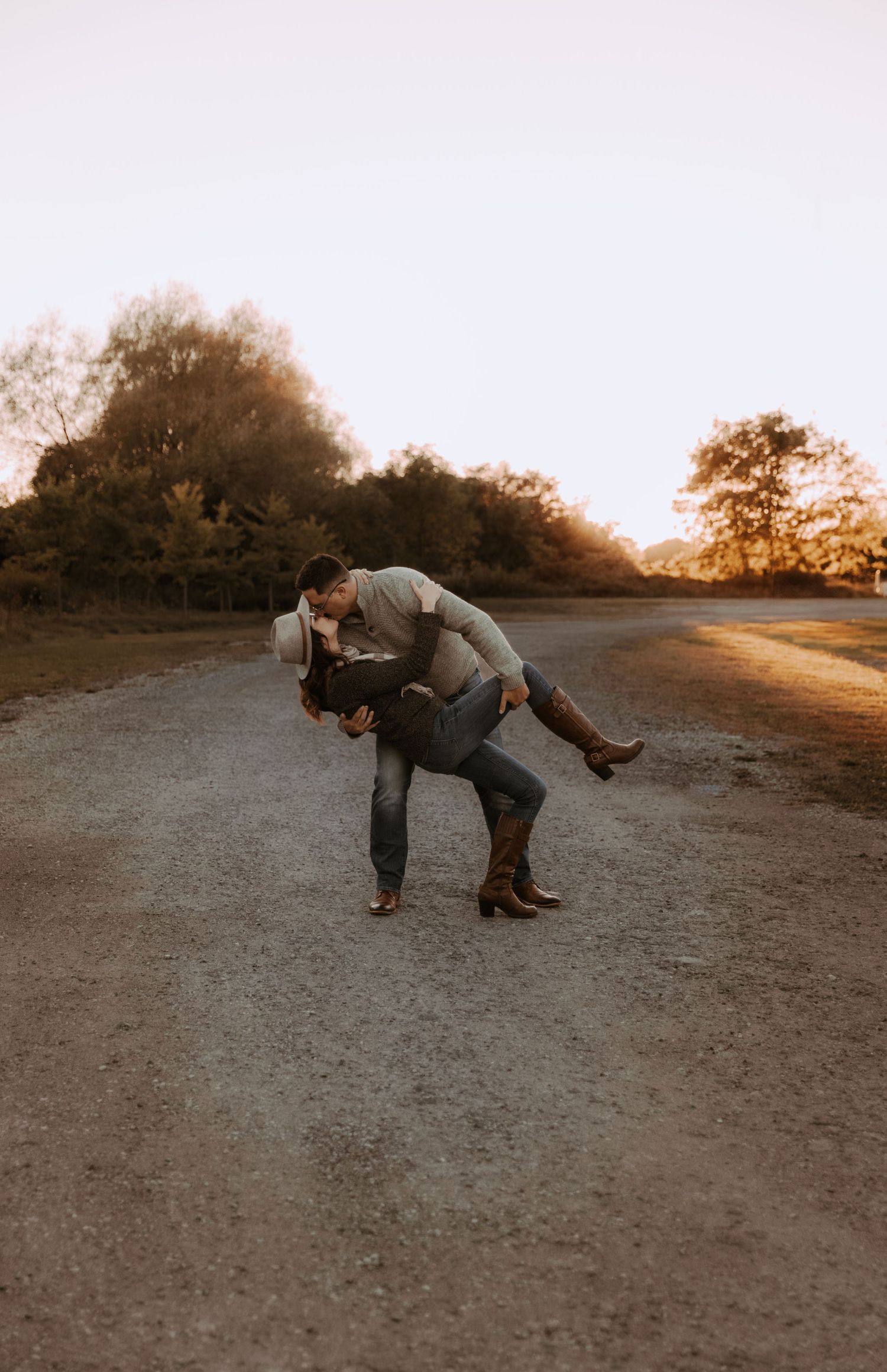 A playful dip pose on a country road during golden hour.