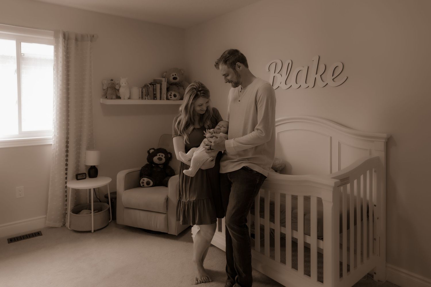 Sepia-toned nursery room interior with a crib, rocking chair, and decorative name 'Blake' on the wall.