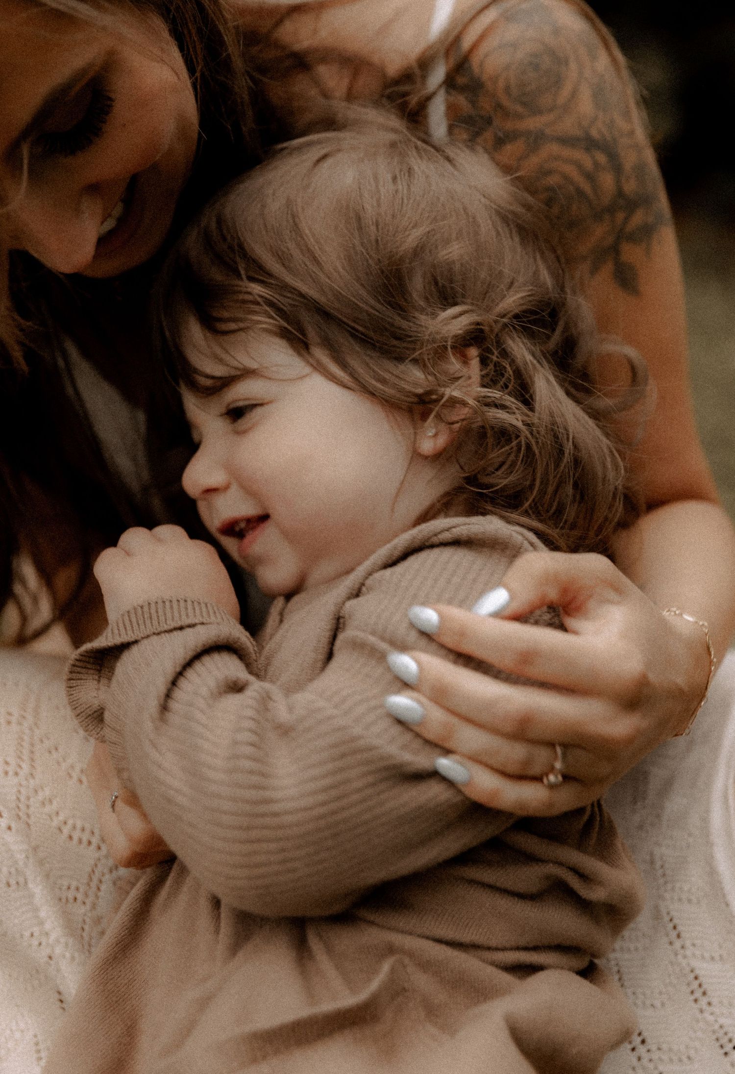 An intimate candid moment showing joy and laughter while cuddling in warm brown tones.