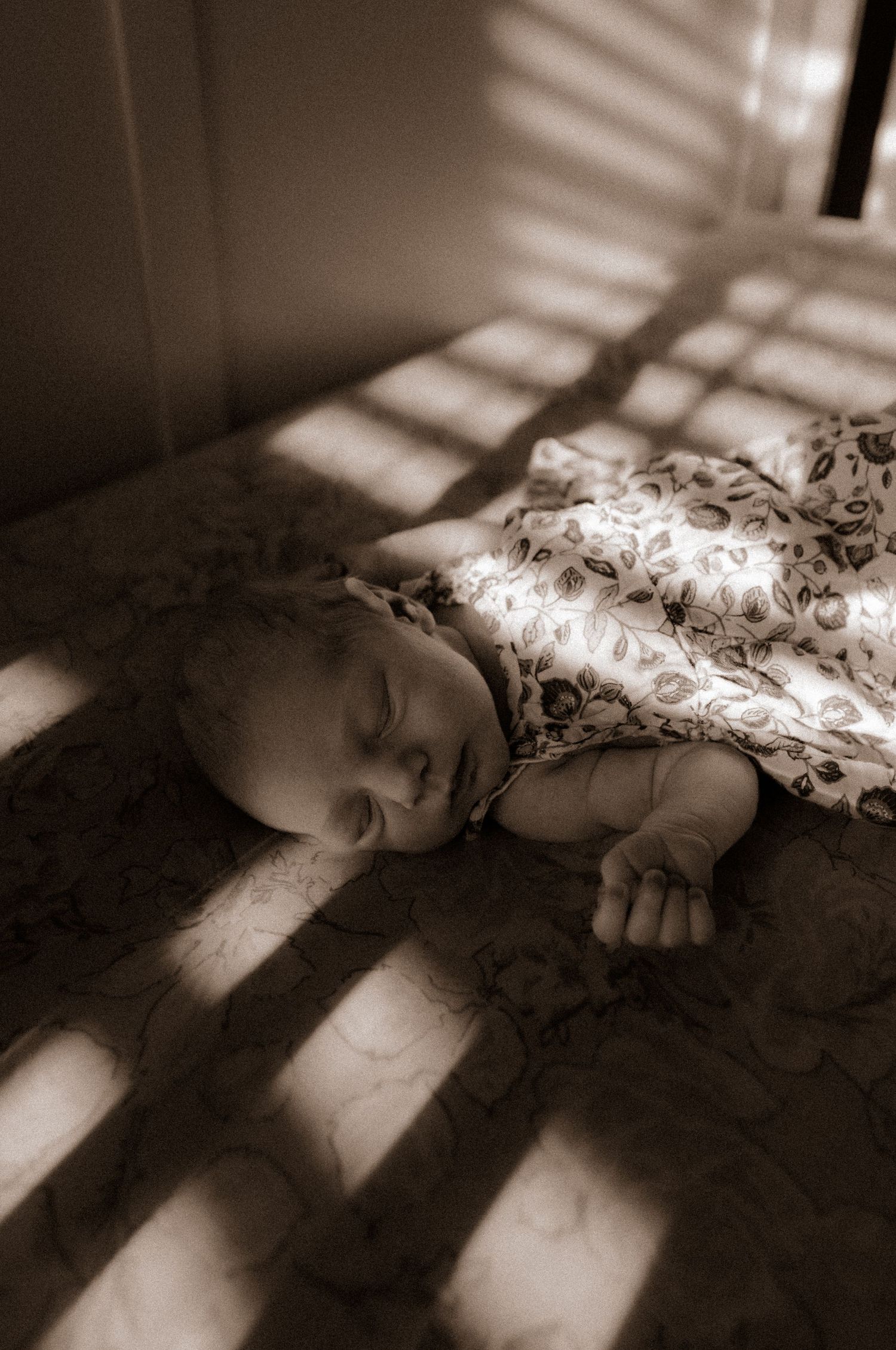 Dramatic window light creates stripes across a peaceful nursery scene.