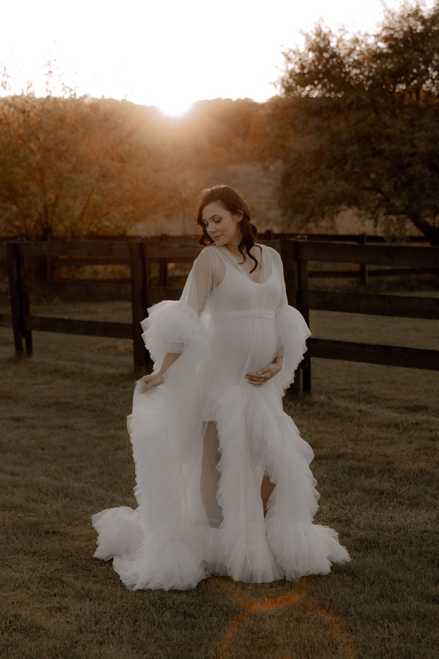 Elegant wedding dress with dramatic tulle details photographed in golden sunset light.