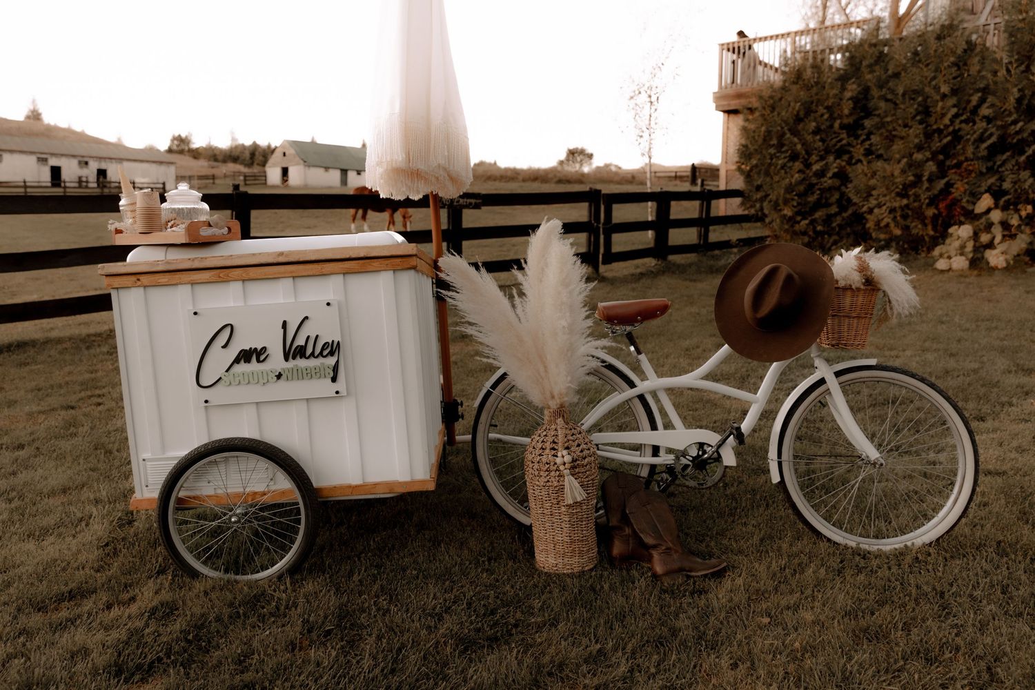 Vintage-style white bicycle and cart setup with rustic wedding decor.