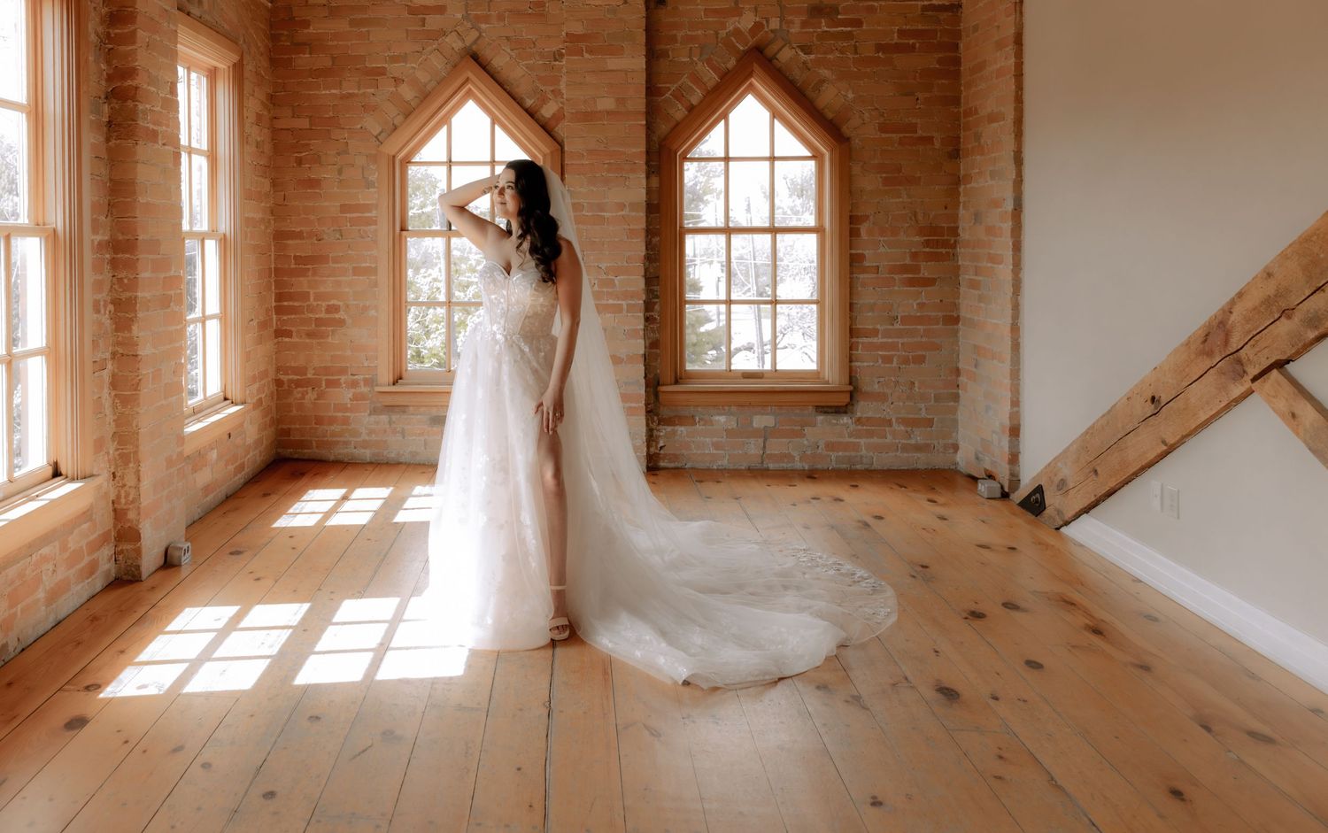 Elegant bridal portrait in rustic brick chapel with gothic windows and natural light.