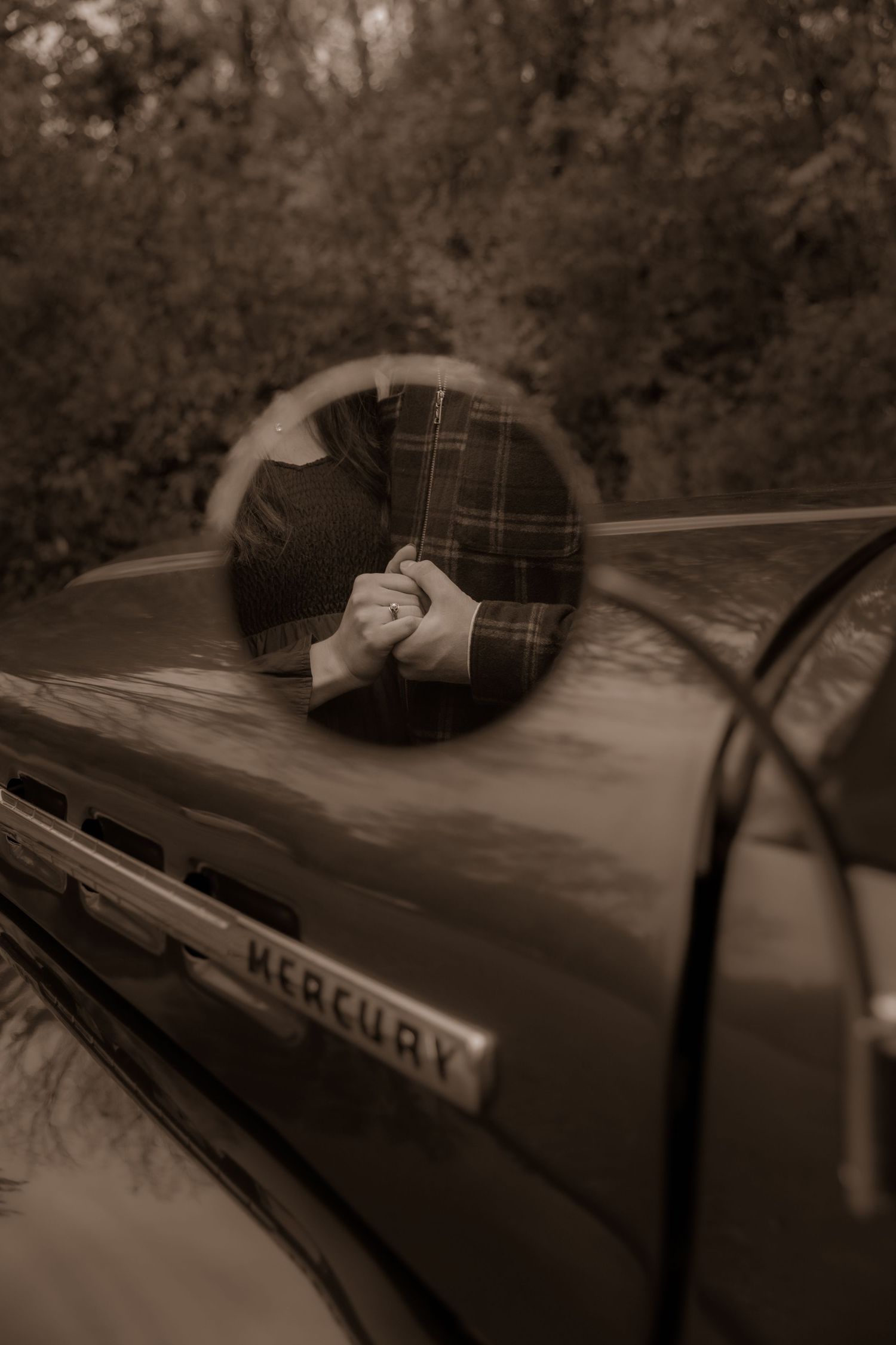 Close-up of classic Mercury truck side mirror detail with plaid shirt reflection.