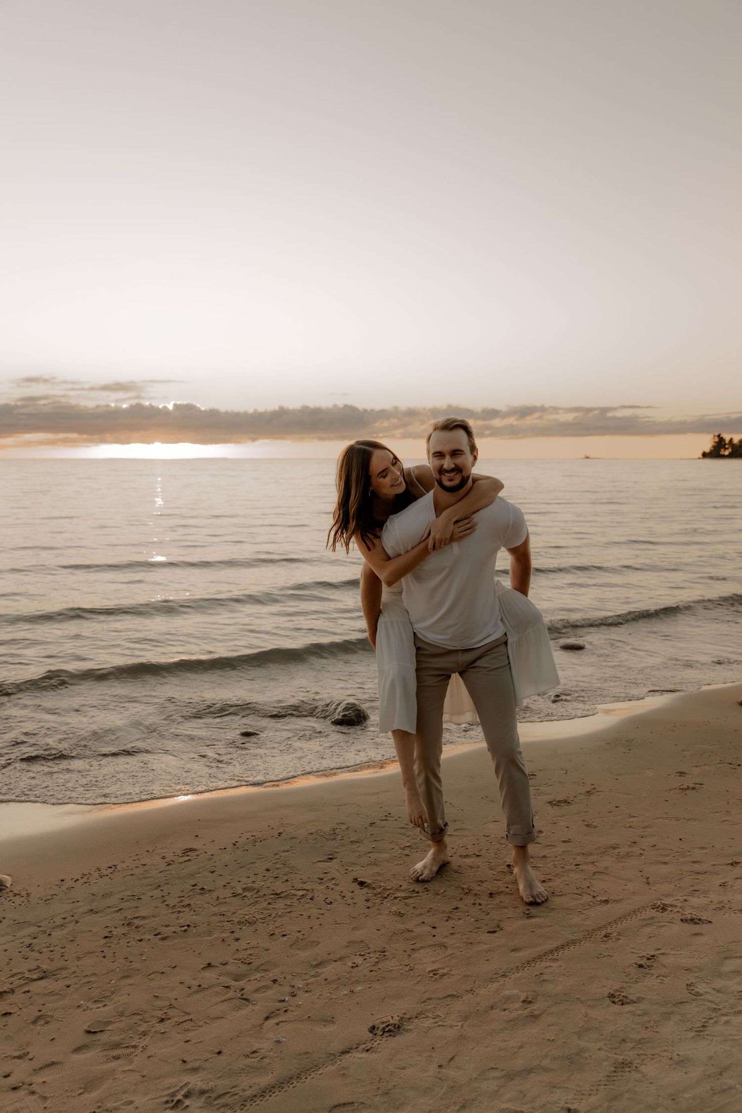 Joyful moment between couple on sandy beach at sunset.
