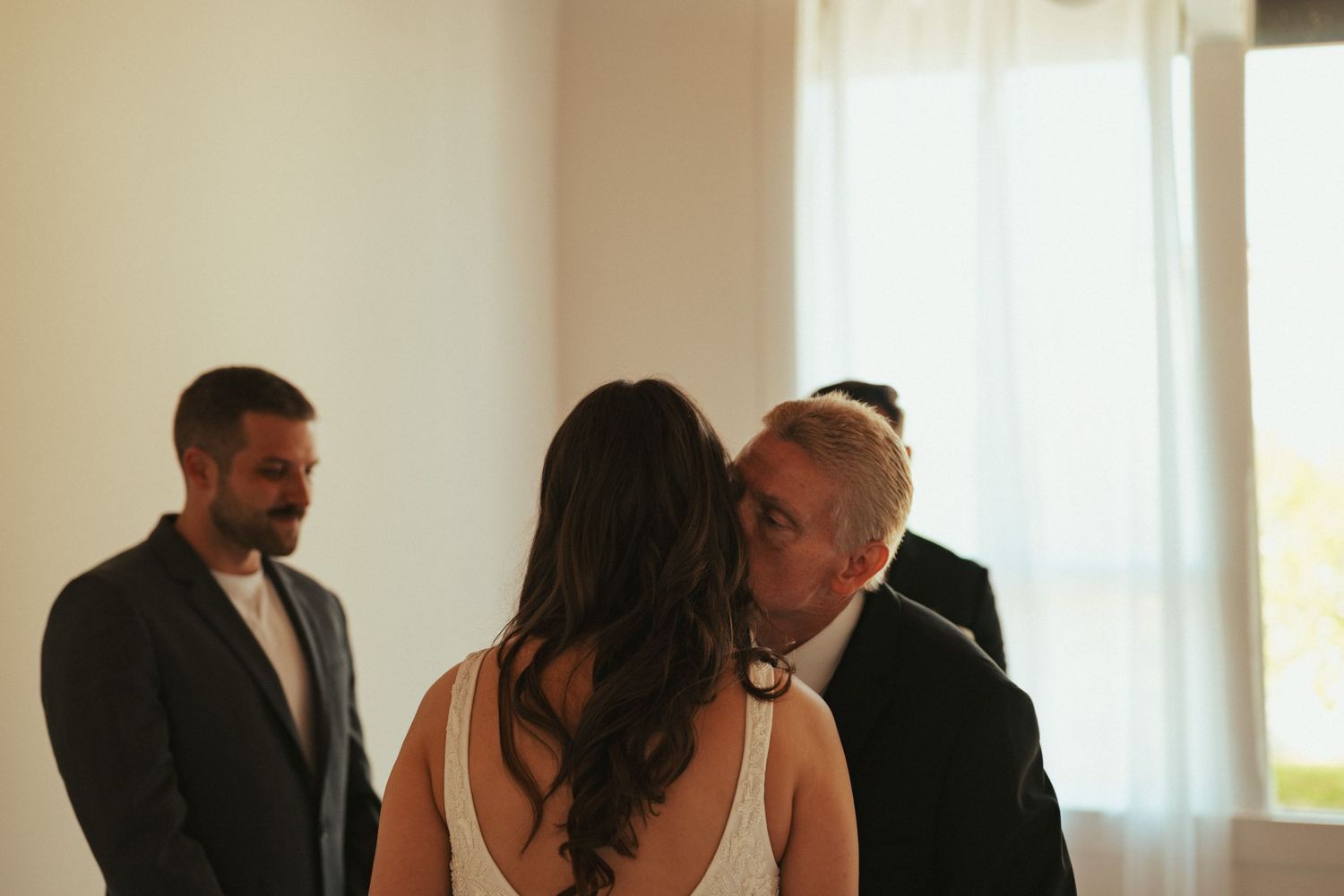 An intimate wedding ceremony moment in a bright minimalist indoor setting.