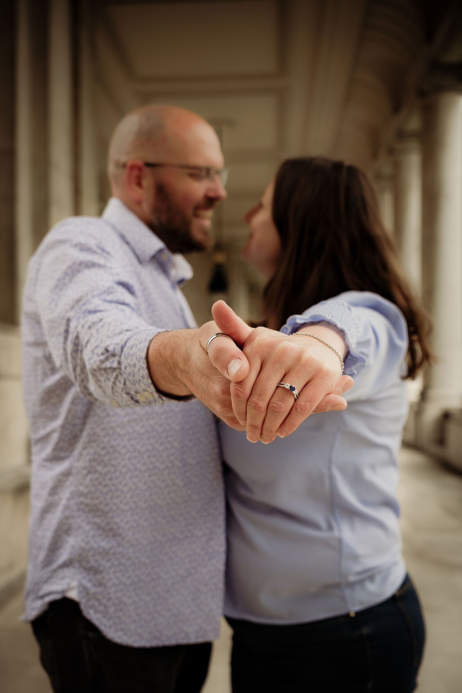 A close-up of hands with engagement rings during a romantic moment.