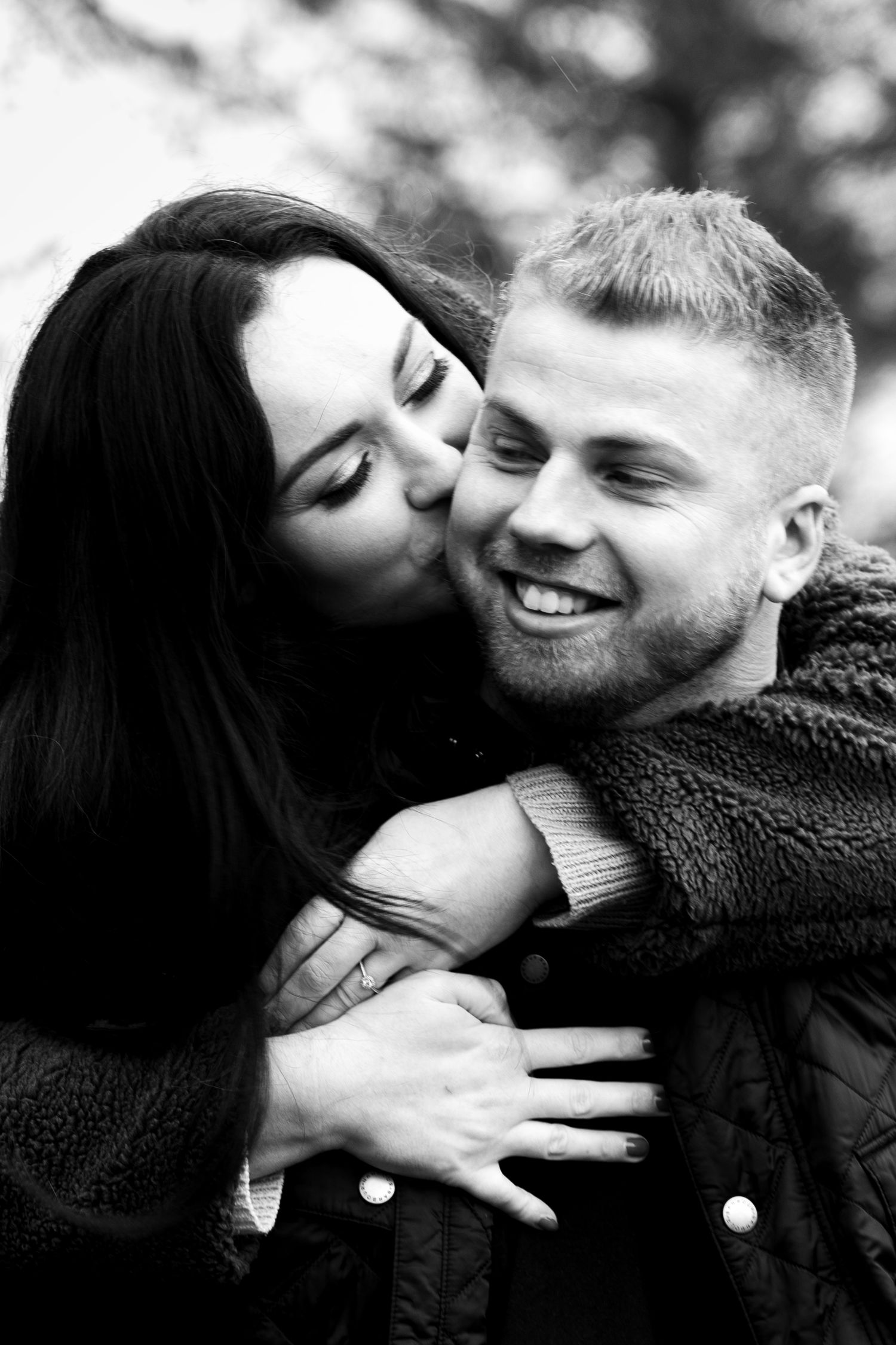 A romantic black and white close-up portrait of an affectionate couple sharing a tender moment.
