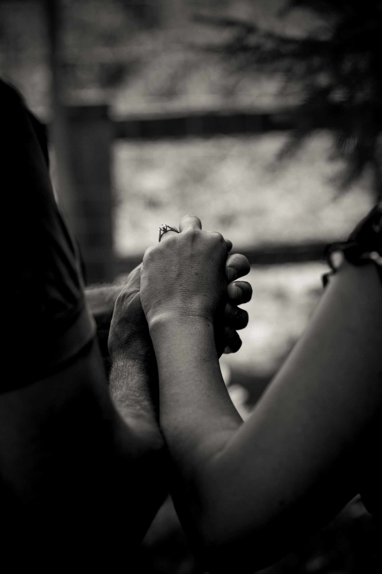 Two hands clasped together in an intimate black and white portrait.