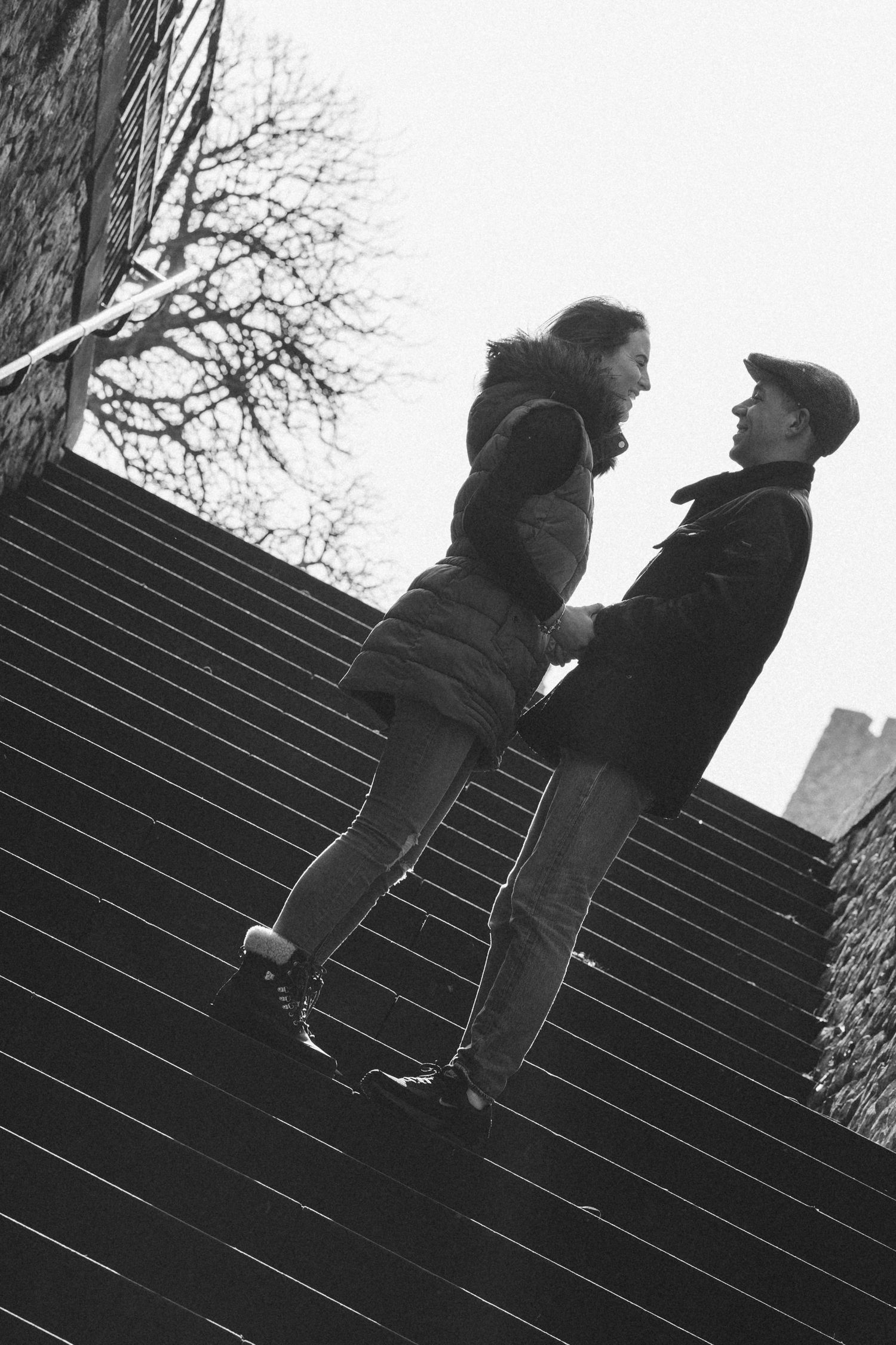 Silhouetted couple standing on stone steps in black and white.