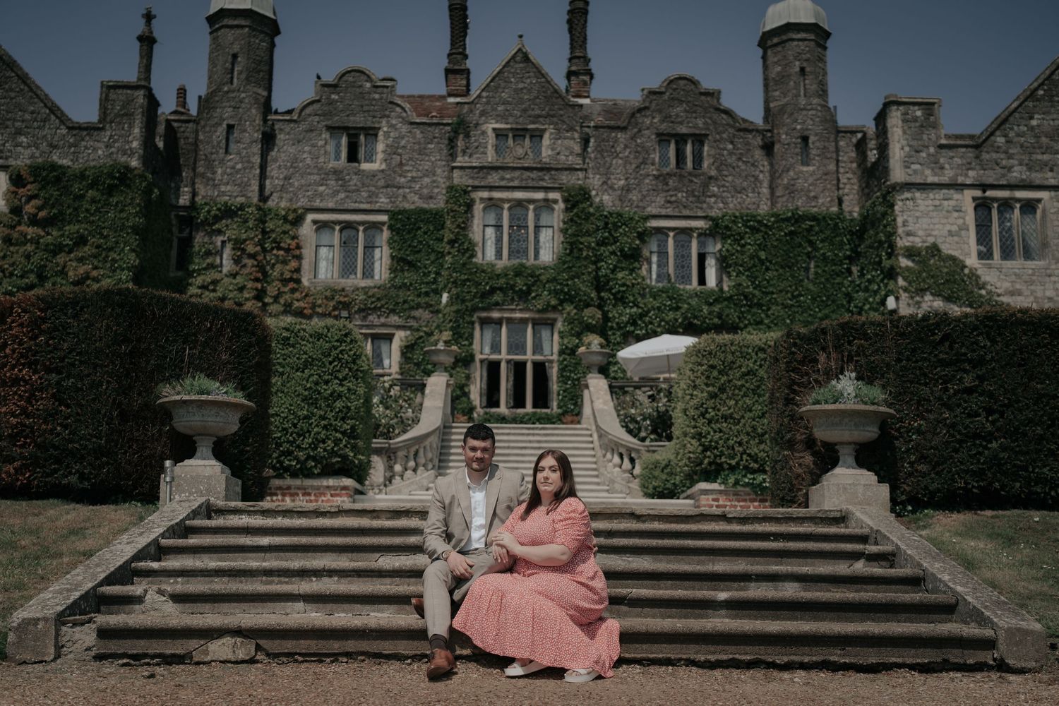 A romantic portrait session on grand stone steps of an ivy-covered historic manor house.