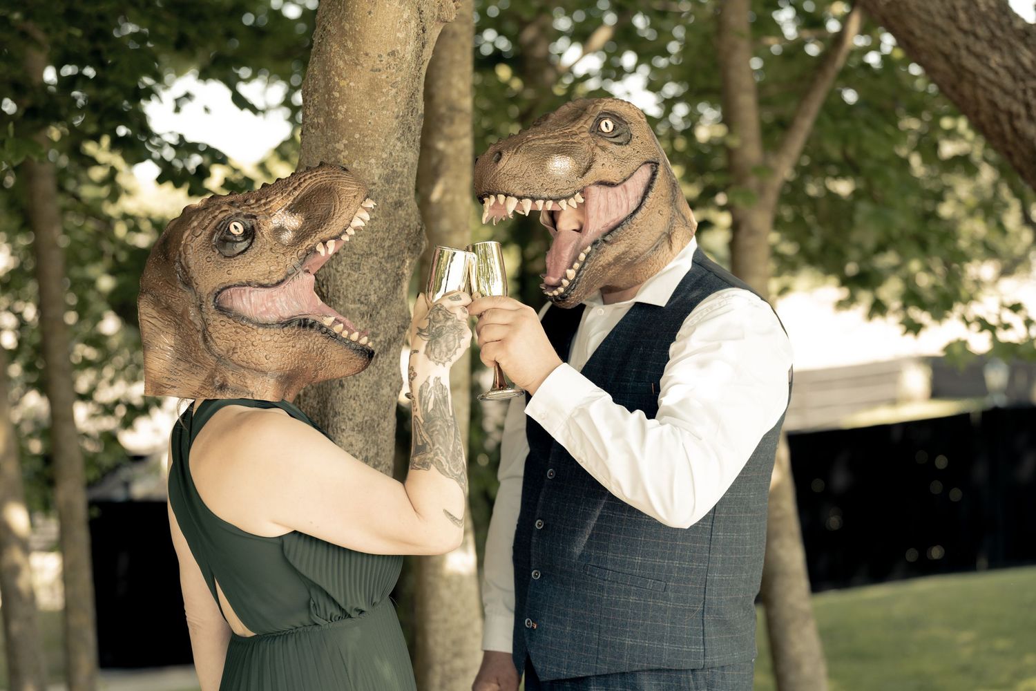 A playful outdoor couples photoshoot under trees with natural lighting and candid laughter.