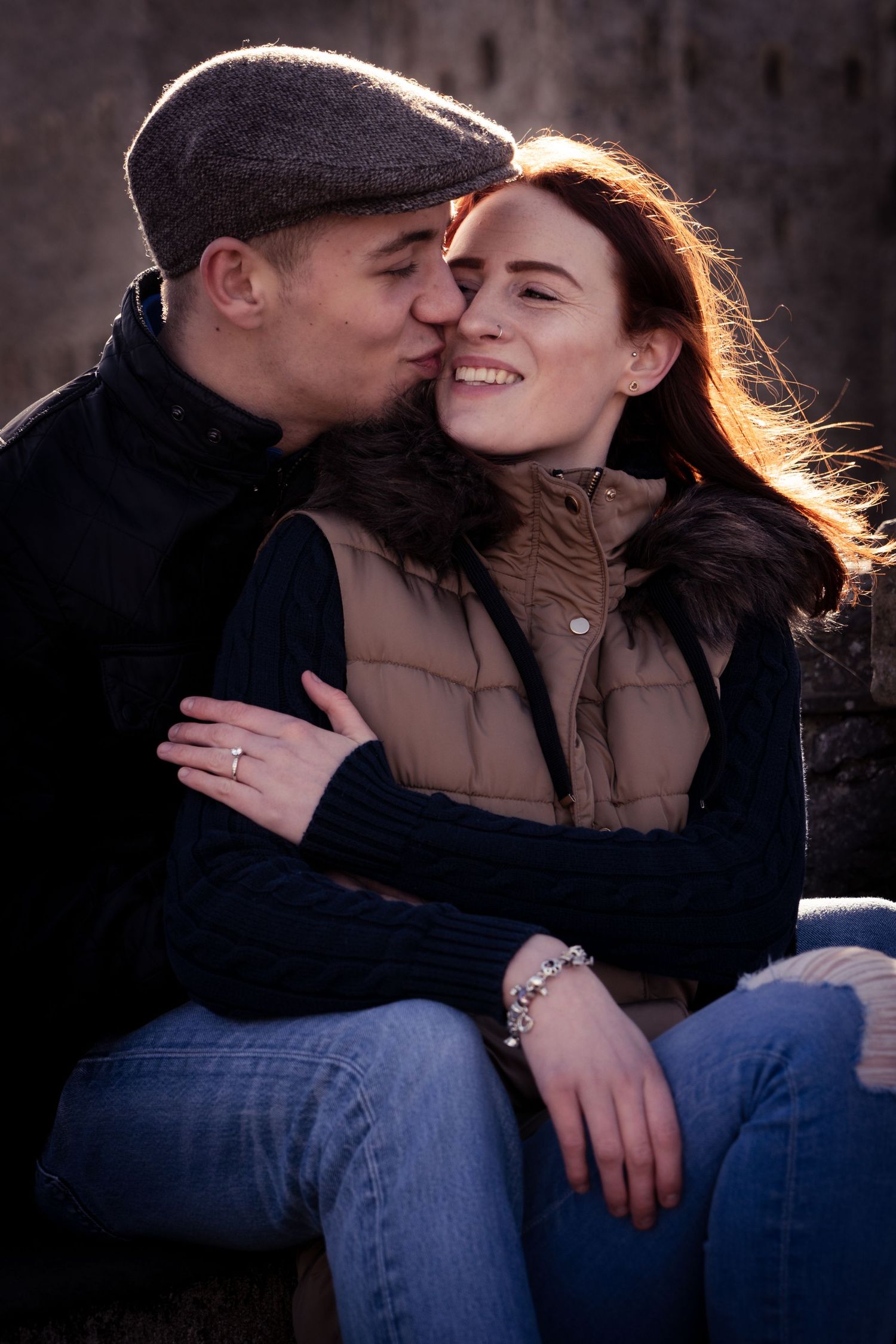 Romantic couple sharing intimate moments in dark lighting while wearing casual clothing.