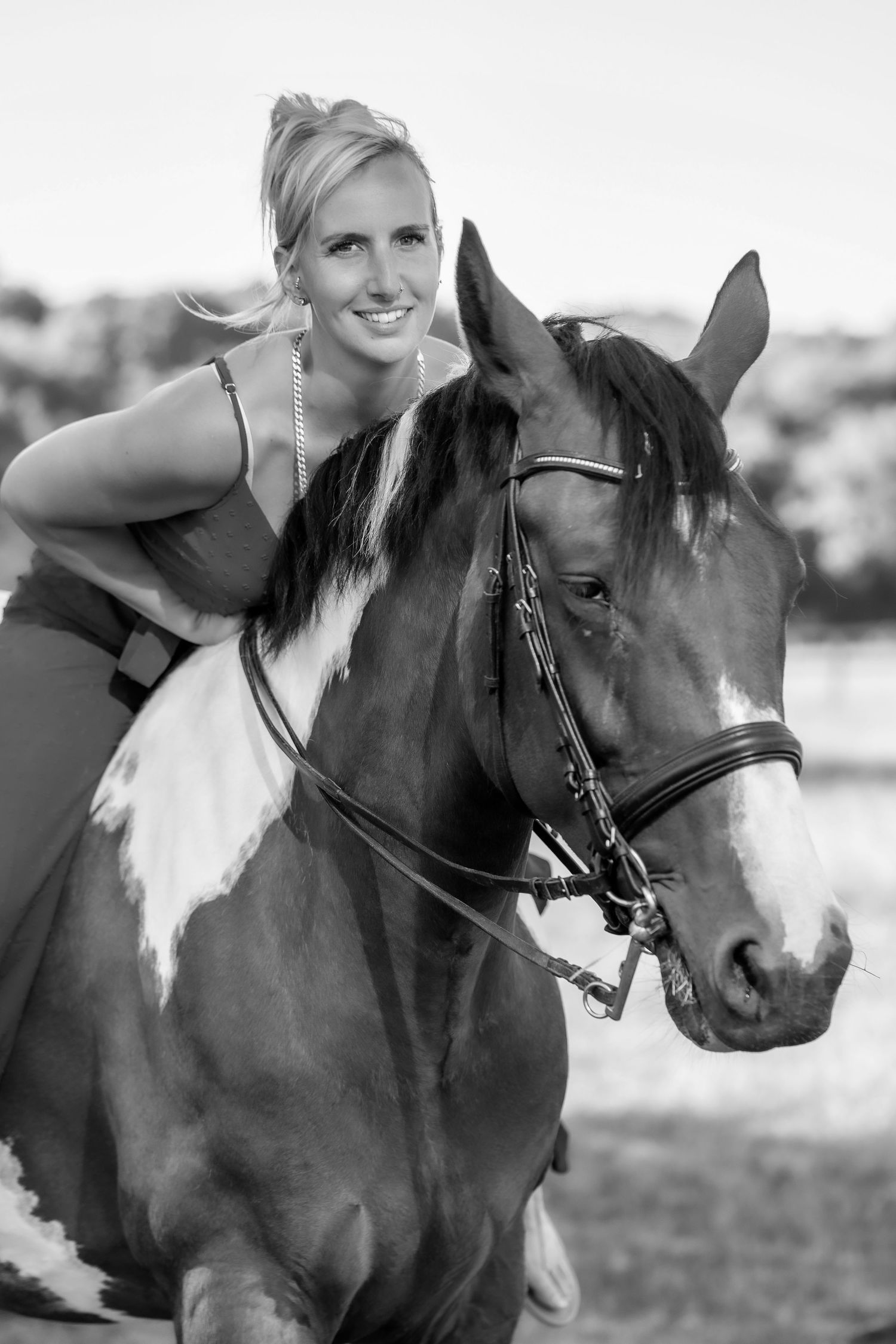 A black and white portrait of an equestrian with a paint horse.