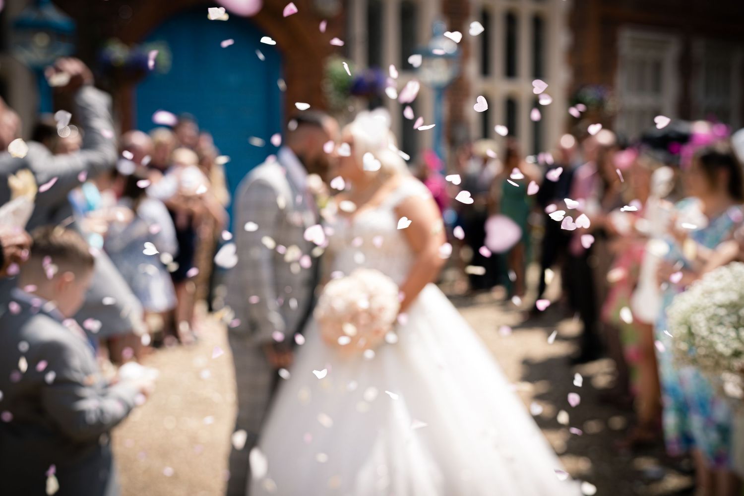 Blurred scene of wedding celebration with confetti flying through the air.