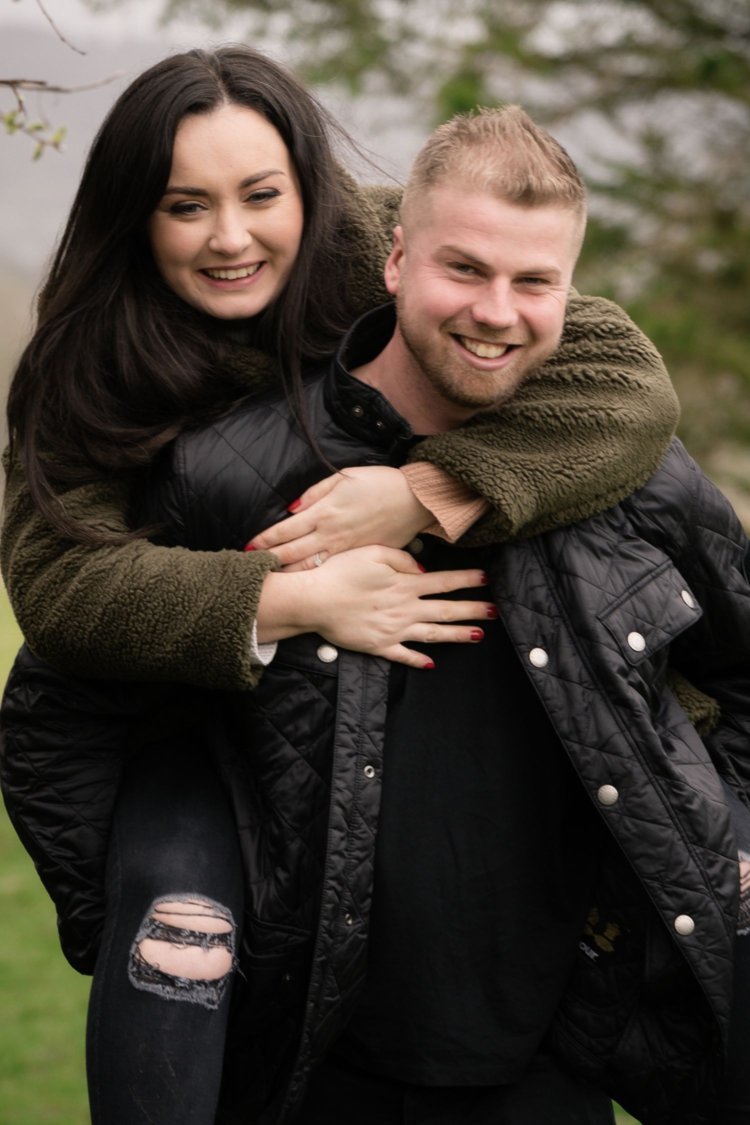 A joyful couple sharing a warm embrace outdoors while wearing winter coats.