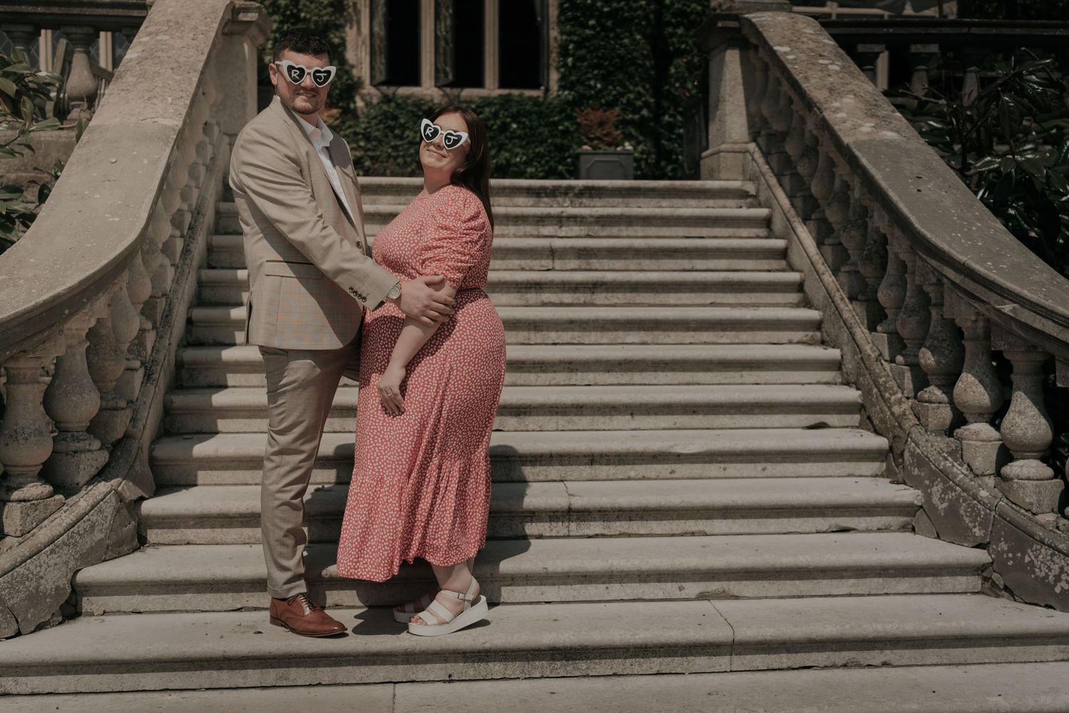 Romantic couple photos taken on elegant stone steps in muted tones.
