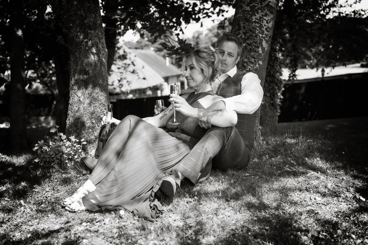 A romantic couples photoshoot with natural sunlight filtering through trees creating a dreamy atmosphere.