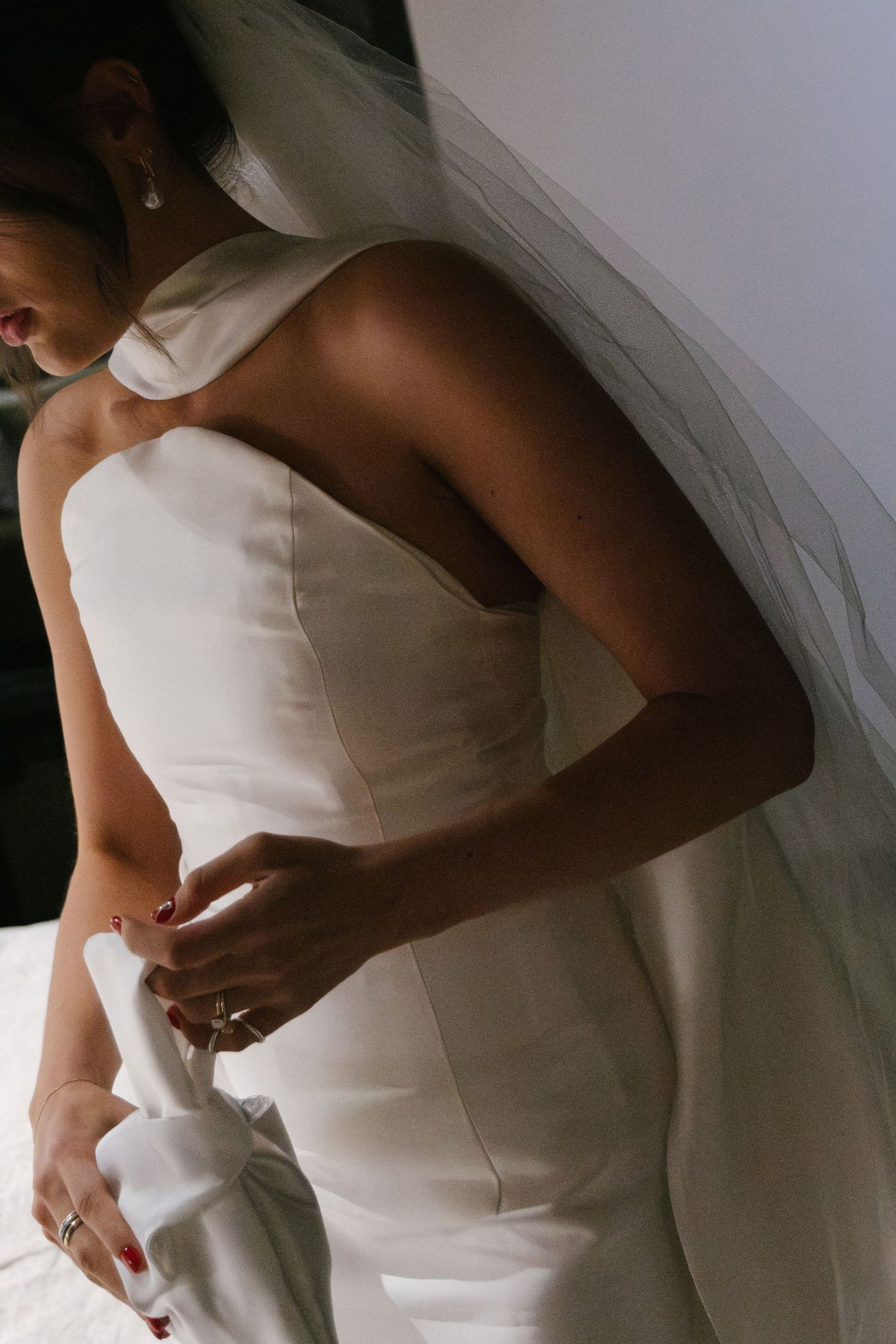 A bride in a white strapless wedding gown adjusts her dress in a series of elegant detail shots.
