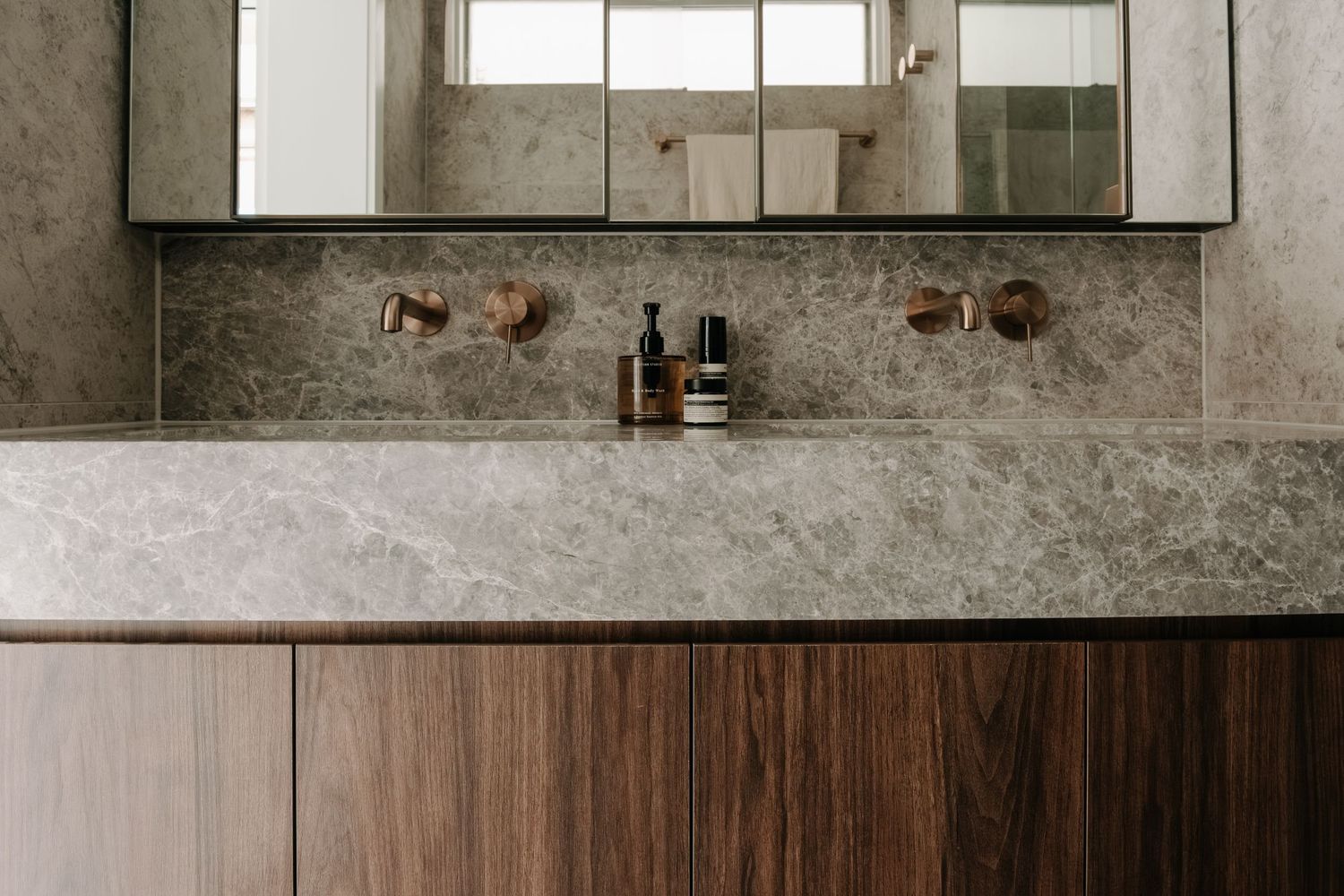 Contemporary kitchen featuring concrete walls, wooden cabinets, and minimalist design elements.