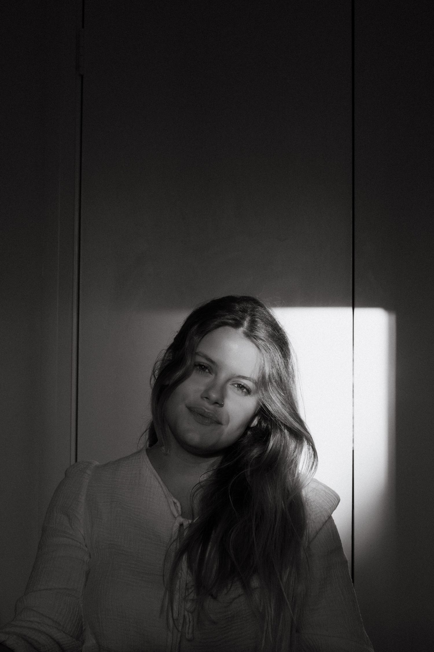 A dramatic black and white photo series shows a person with long hair in varying shadowy poses against a dark background.