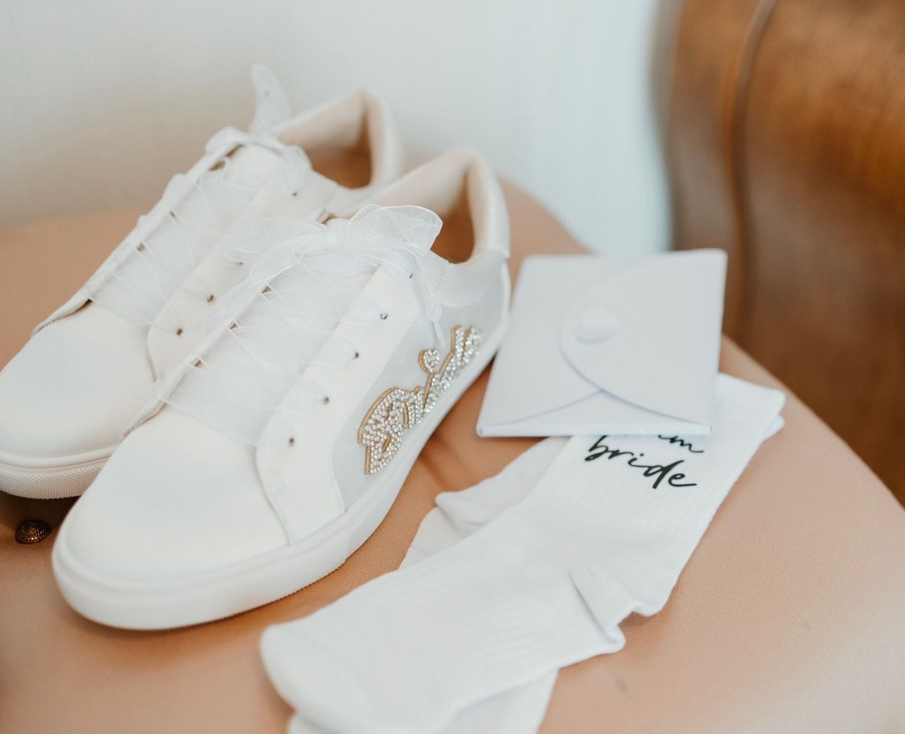 Multiple white leather sneakers arranged in different angles showing minimalist design and clean aesthetic.