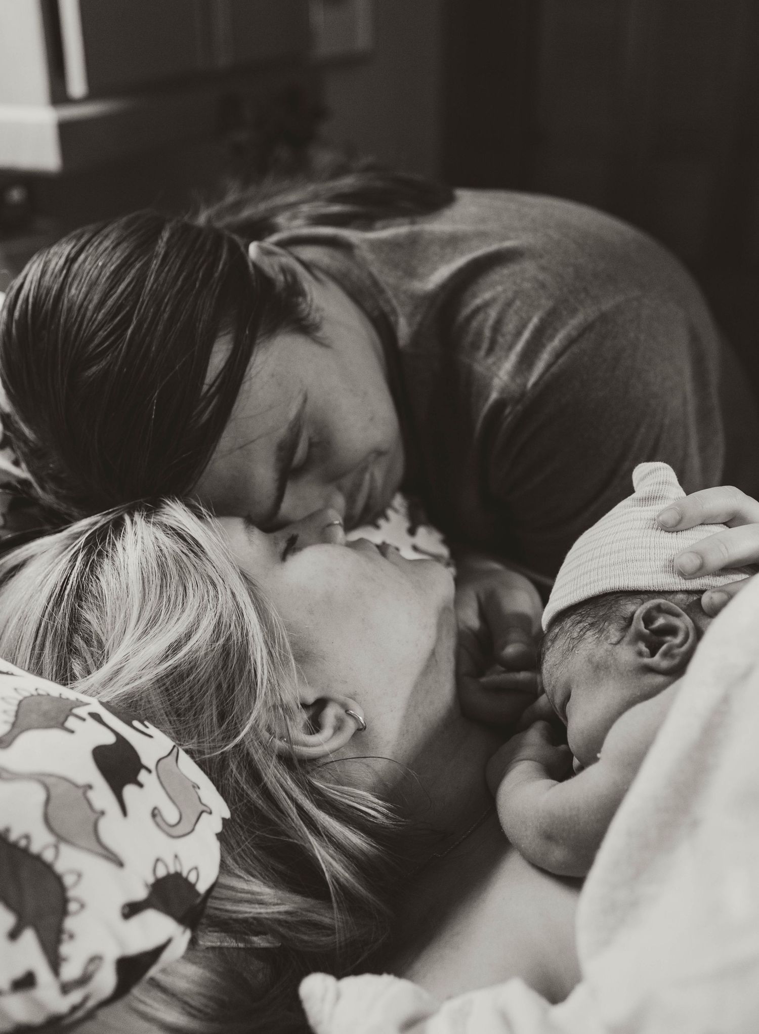 A tender black and white photograph capturing an intimate family moment with a newborn baby. Dallas + East Tx birth and newborn Photography