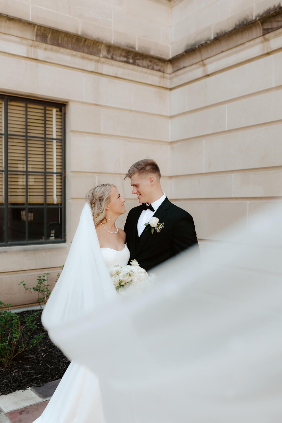bride and groom posing in the courtyard of the nebraska state capitol building in lincoln nebraska, wedding photos in lincoln