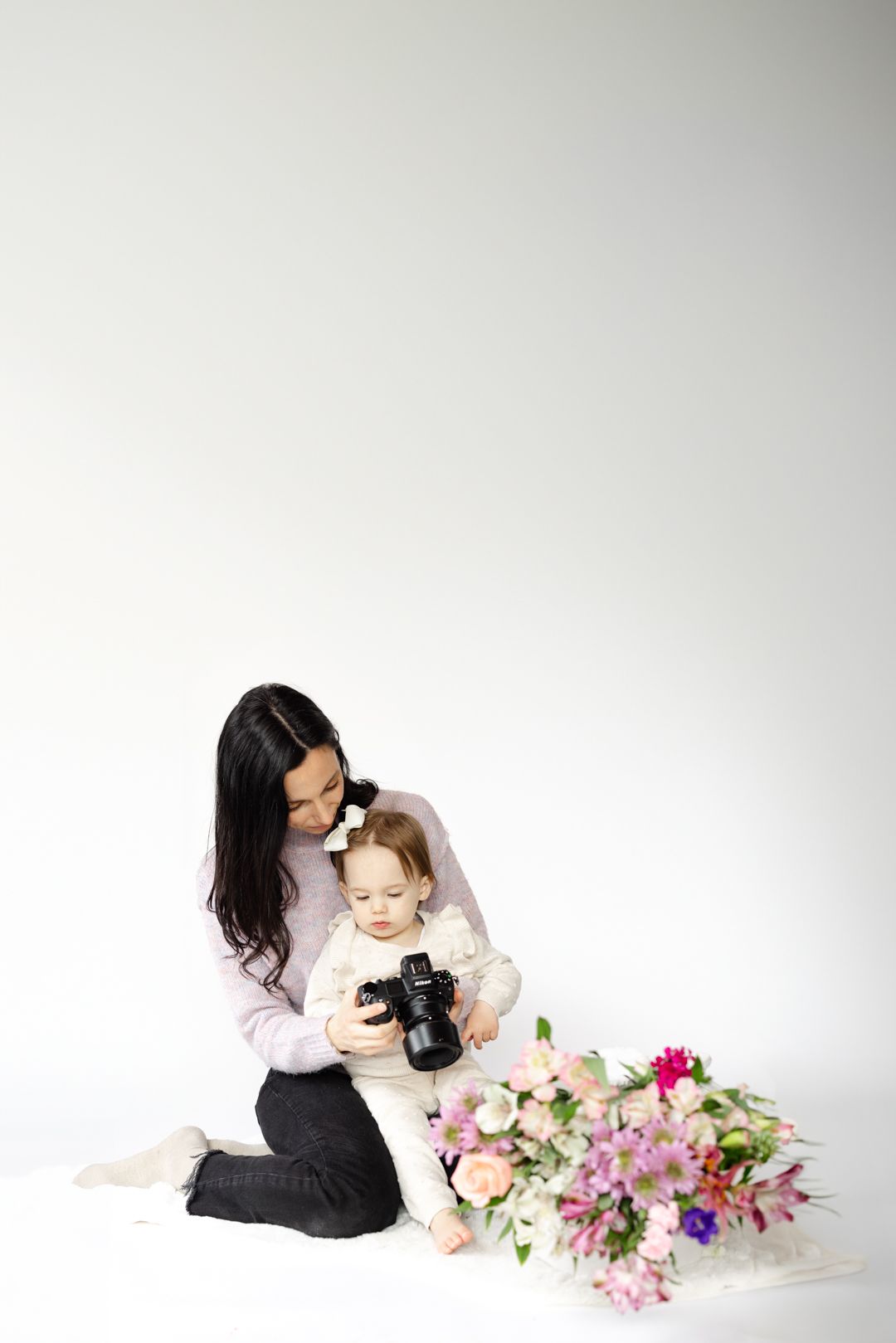 A touching moment with a camera and flowers on a white background.