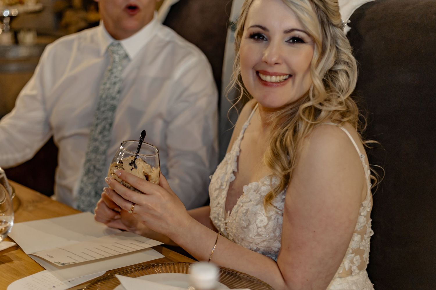 A bride reacts with joy and excitement during a candid wedding moment at a reception venue.