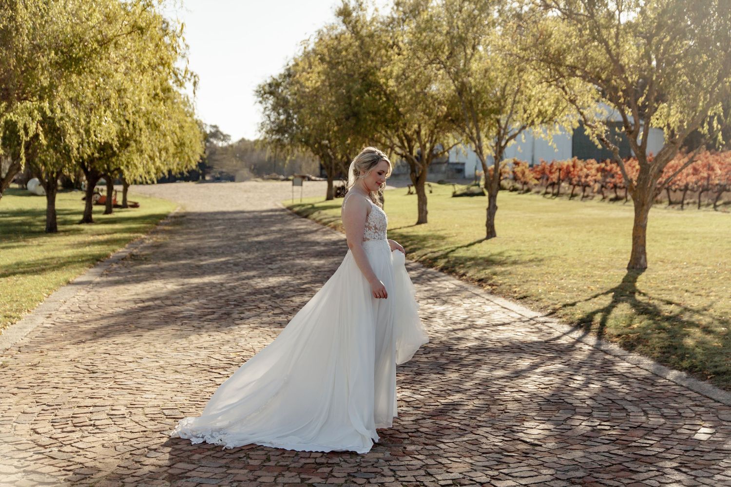Multiple views of a flowing white wedding gown photographed against rustic cobblestones and autumn trees.
