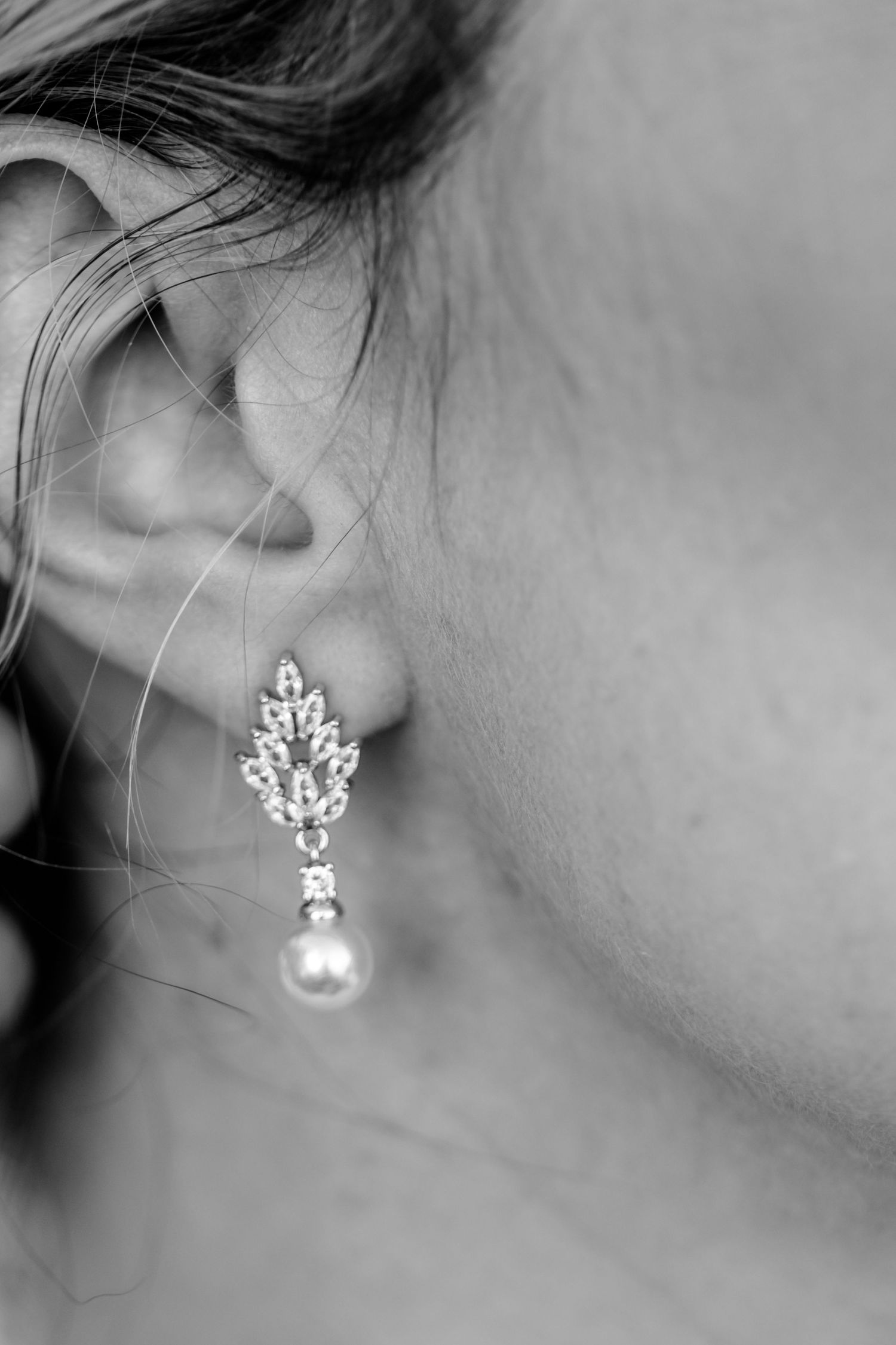Close up photos show a collection of delicate pearl and crystal drop earrings in elegant designs against gray backgrounds.