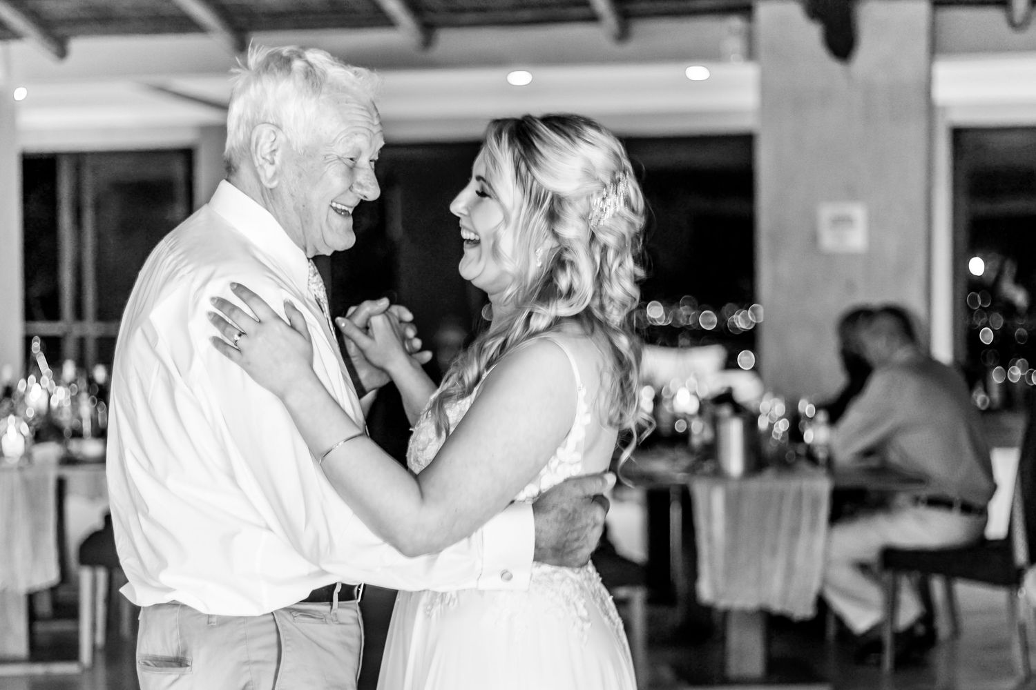 A bride and her dance partner share an emotional moment during a dance at a wedding reception.