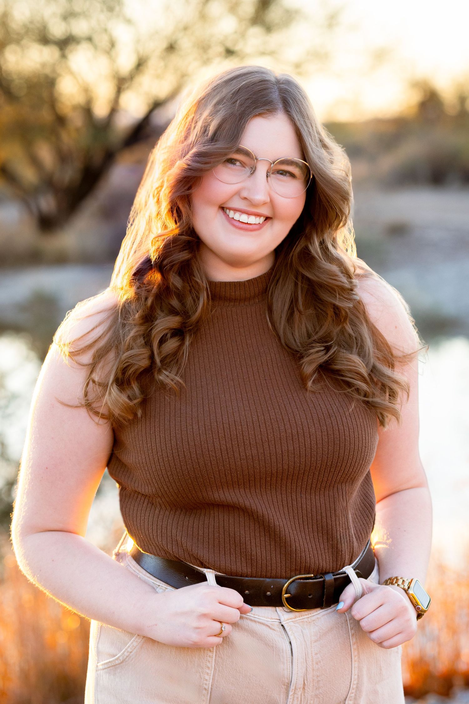 Portrait in warm sunset light wearing brown ribbed top and khaki pants.