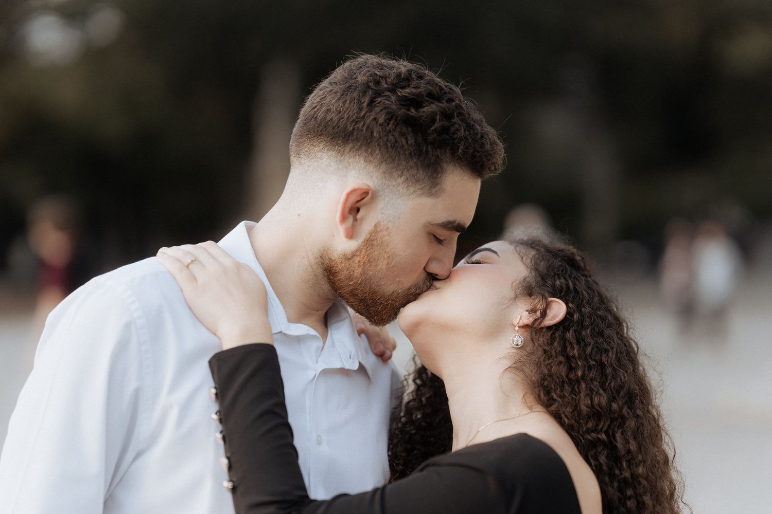 Casal romântico compartilhando um beijo carinhoso ao ar livre em um ambiente natural suave. Sessão de solteiros no Bom Jesus de Braga.