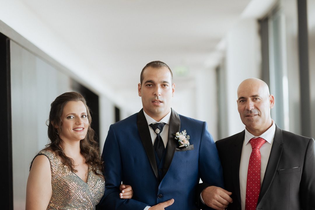 Wedding party in formal attire stands together during elegant celebration in modern venue.