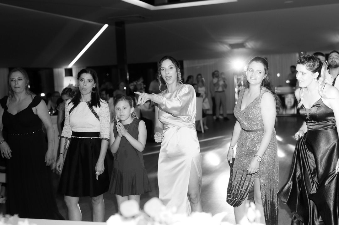 A group of people laugh and dance together on a dance floor during what appears to be a celebration or party.