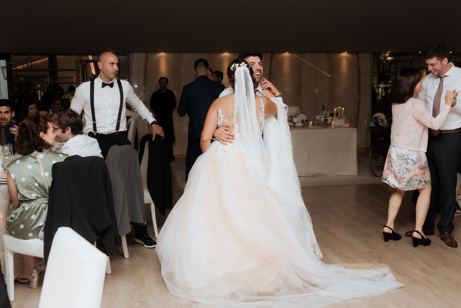 Bride and groom share first dance on elegant dance floor at wedding reception.
