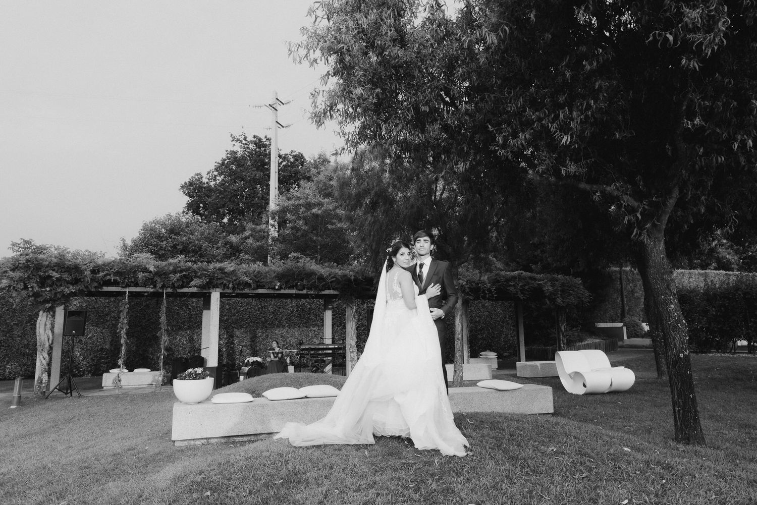 Black and white photo of a romantic outdoor wedding celebration with a beautiful ceremony setup in a garden setting.