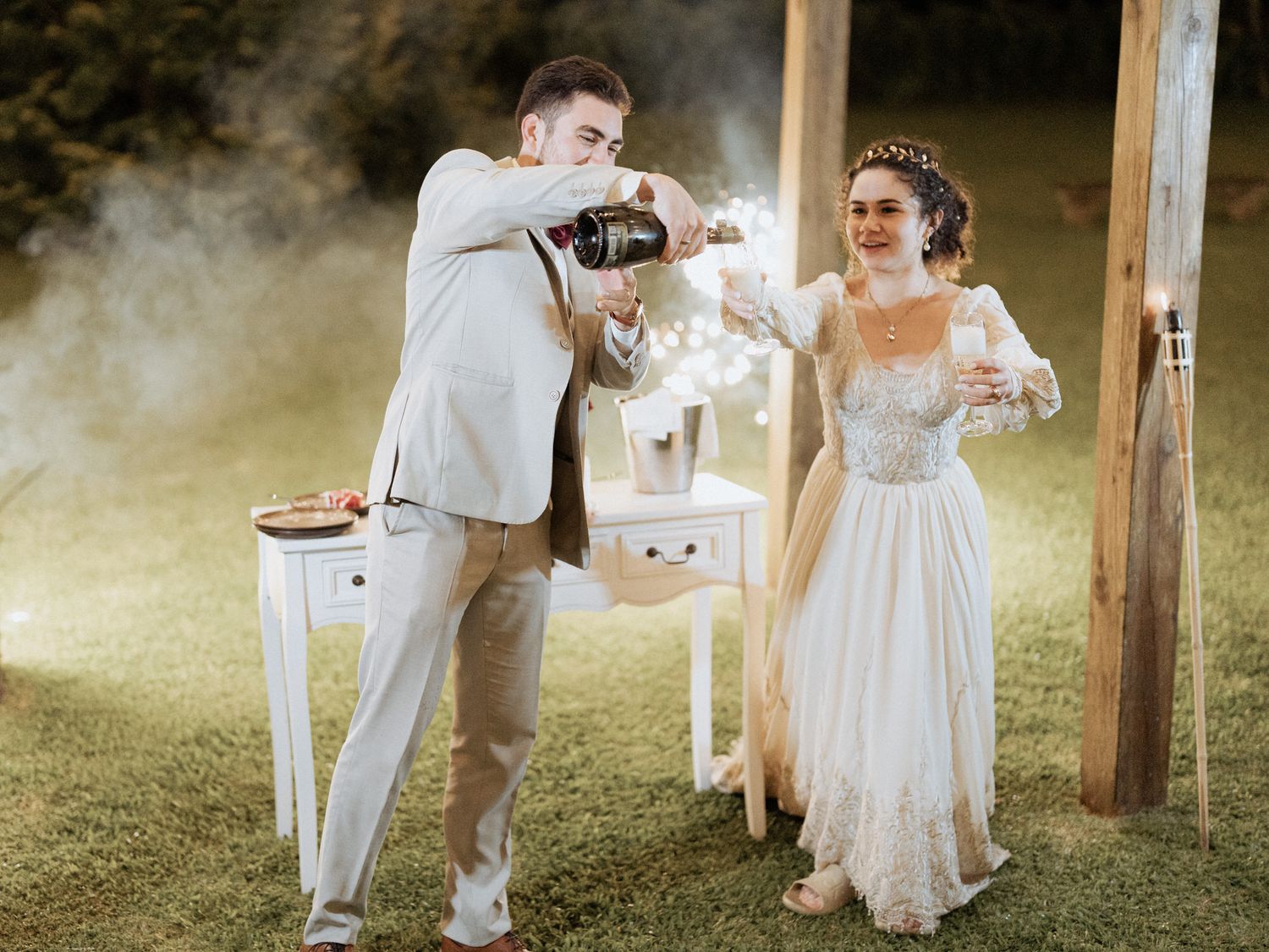 A couple performs a champagne celebration during their outdoor rustic wedding ceremony.