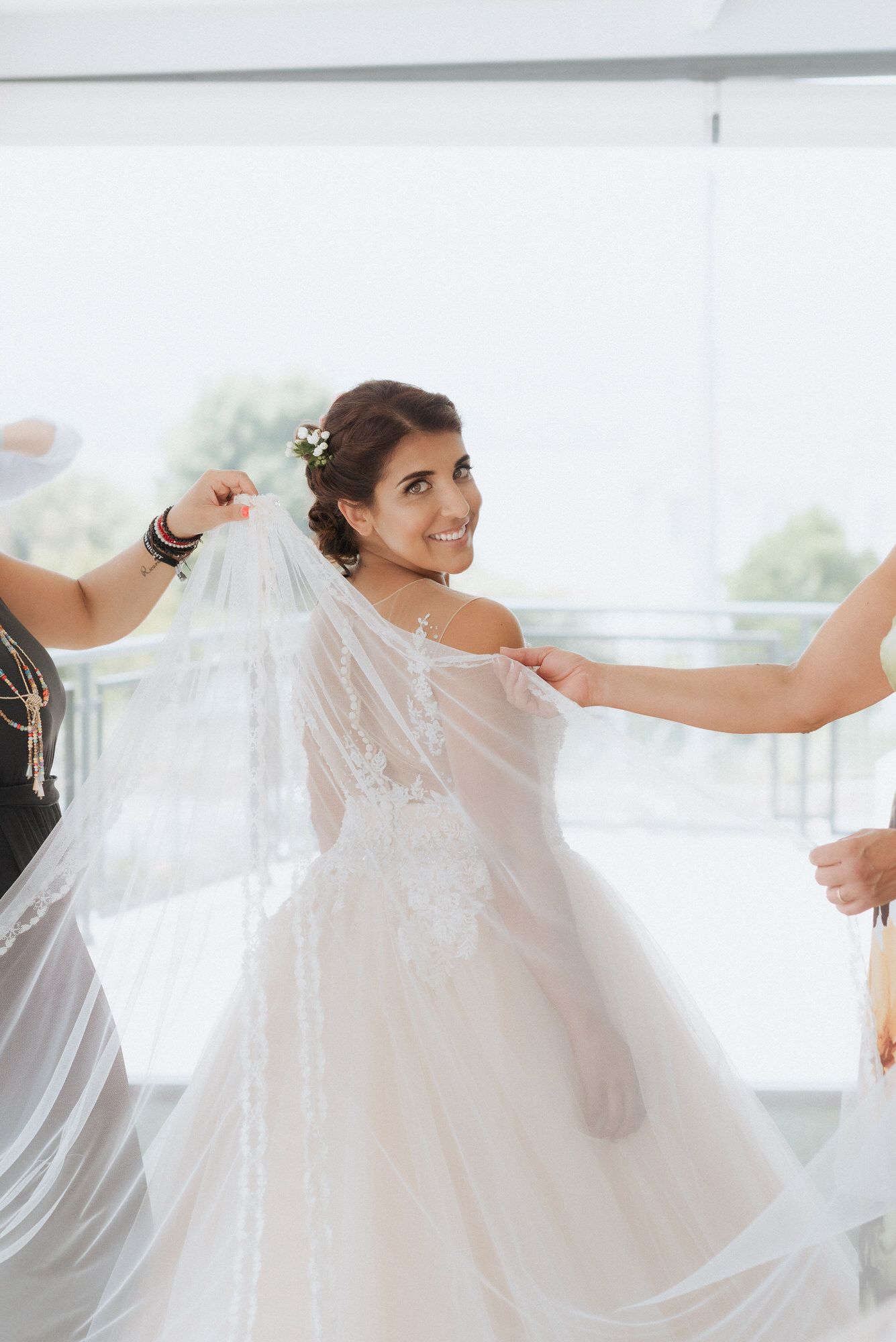 A graceful bride in a flowing white dress twirls as her veil catches the light in an elegant moment during her wedding.