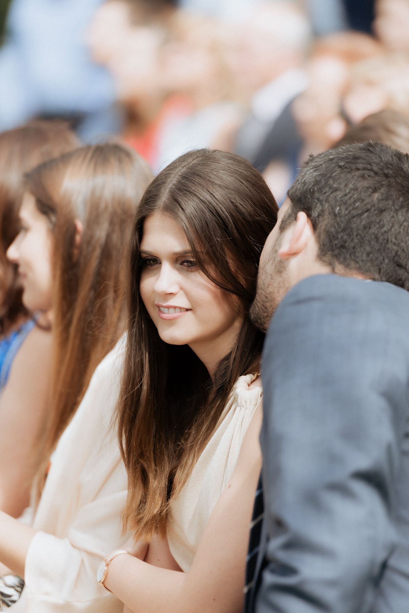 A blurred crowd of people sitting together at a formal event with soft focus and shallow depth of field.