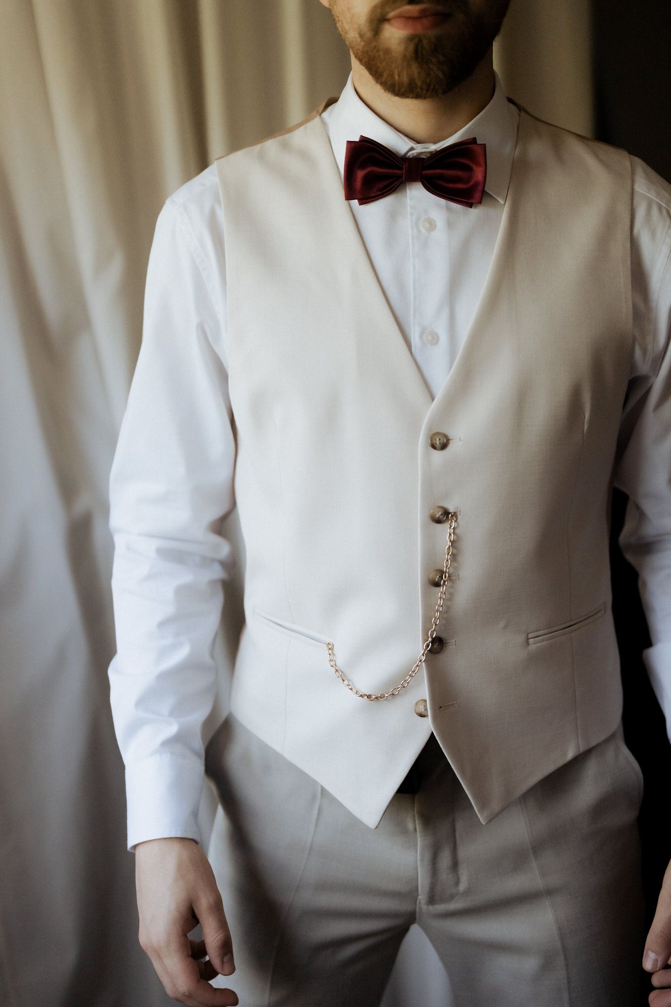 Elegant white tuxedo vest with bow tie and chain detail shown in multiple detail shots from torso level.