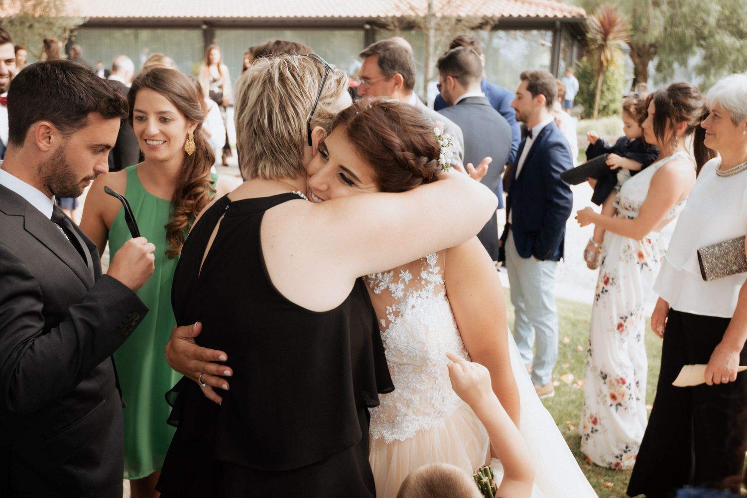 Wedding guests dance and embrace on an outdoor dance floor during an elegant outdoor celebration.
