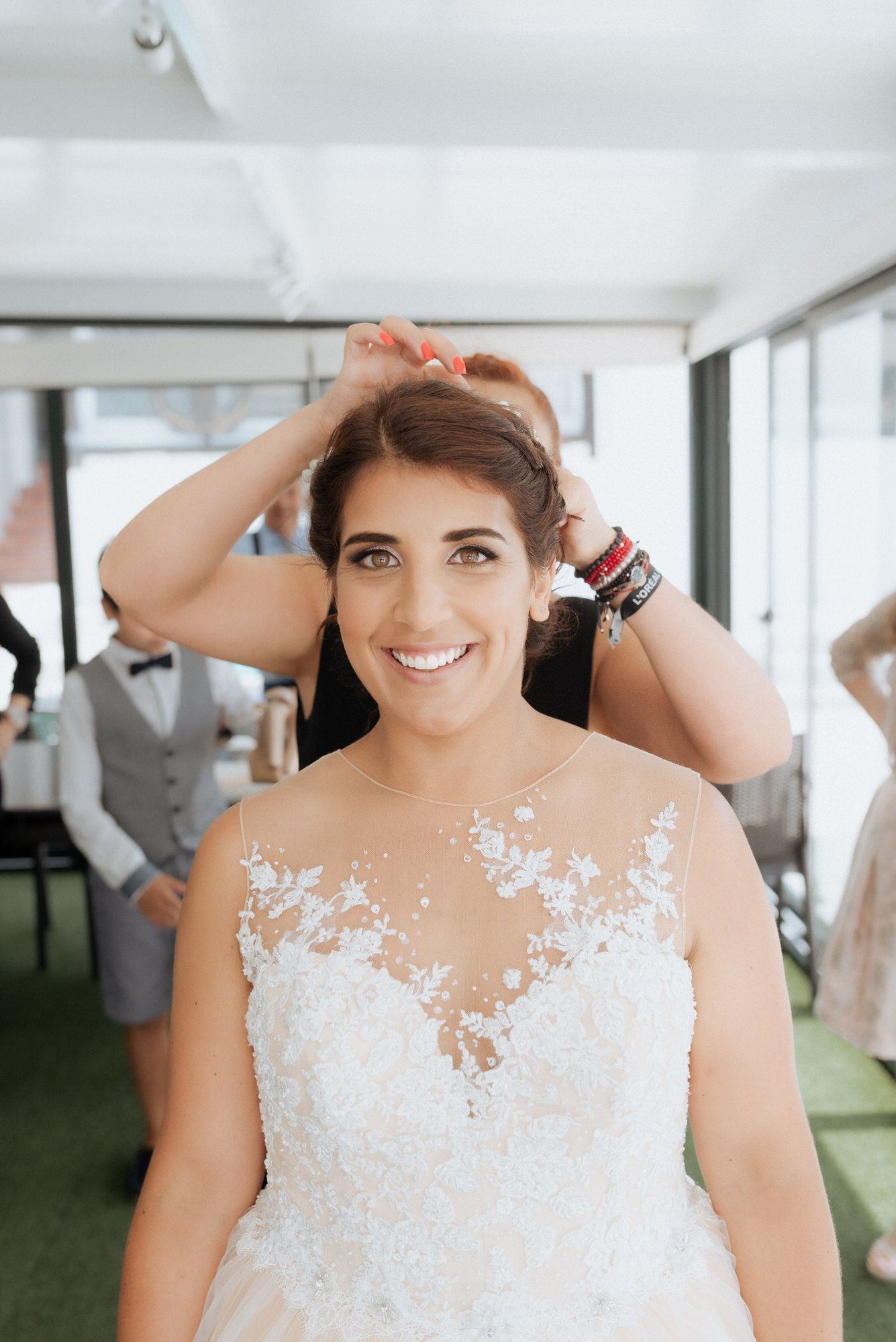 Beautiful wedding dress with delicate lace details and illusion neckline shown in a bright interior setting.