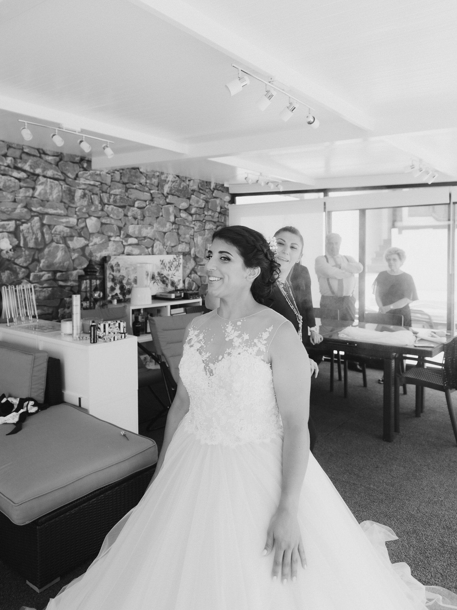 A panoramic series of black and white wedding venue shots showing a rustic stone wall room with modern seating areas.