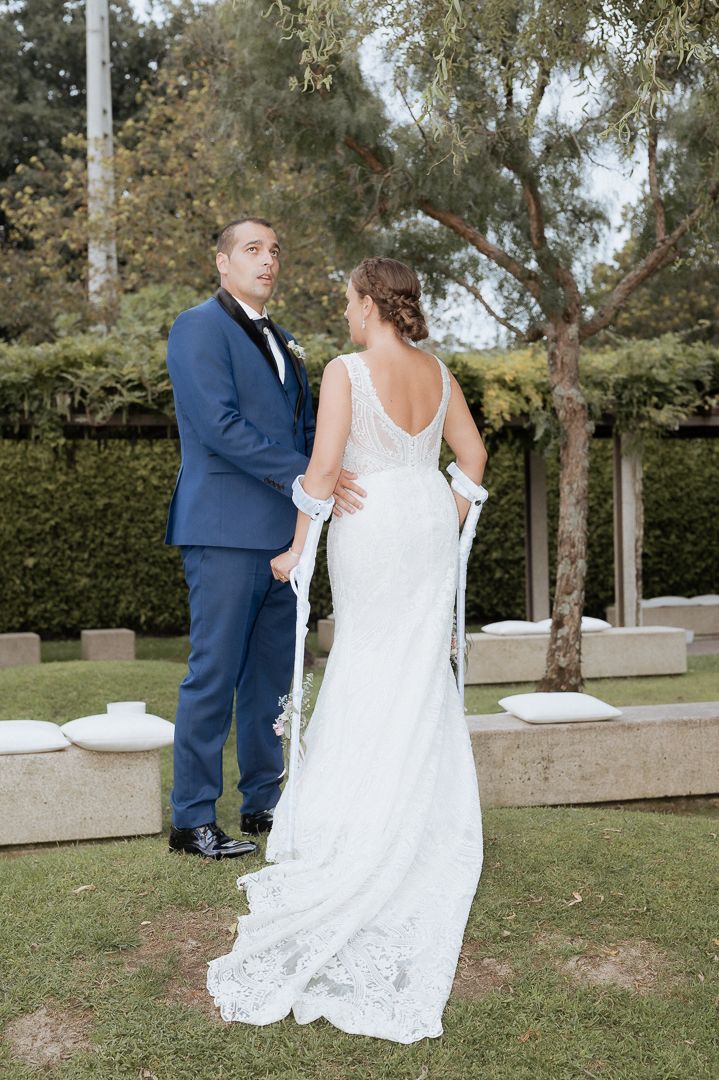 A couple shares a romantic moment during their garden wedding ceremony, with the bride wearing a white lace gown.